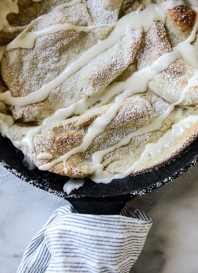 vanilla cinnamon roll dutch baby with apple bourbon compote and cream cheese icing I howsweeteats.com