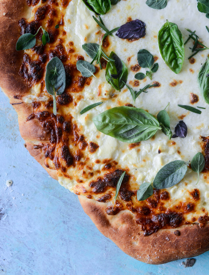 white pizza with garlic sauce and garden herbs I howsweeteats.com