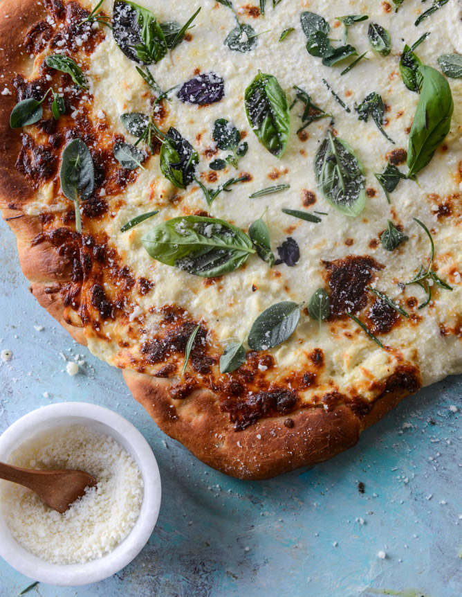 white pizza with garlic sauce and garden herbs I howsweeteats.com