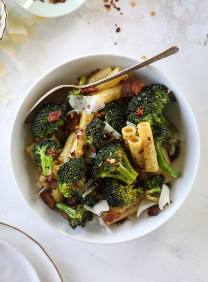 This is the easiest weeknight bacon broccoli pasta that can come together in minutes! Super flavorful and filled with crispy bacon, fresh broccoli, shaved parmesan and crushed red pepper, it's delicious on its own or as a base for more veggies or meat! I howsweeteats.com #bacon #broccoli #pasta #easy #dinner #recipes