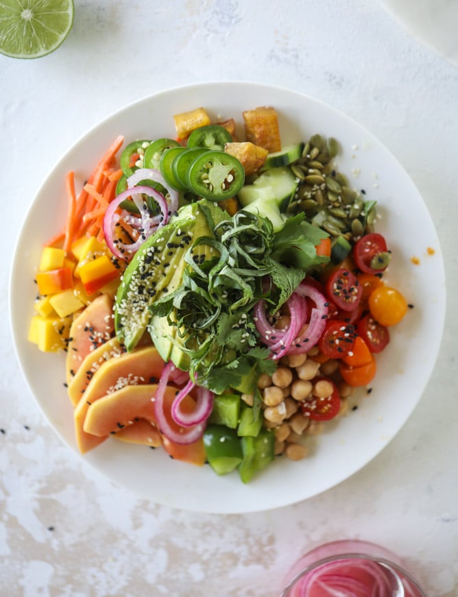 This spicy rainbow salad is chock full of gorgeous, fresh produces, chickpeas, plantains and herbs for one beautiful sight in a bowl. The rainbow salad is satisfying, filling, delicious with a touch of sweet and slightly spicy - everything you want in a meal! I howsweeteats.com #spicy #rainbow #salad 