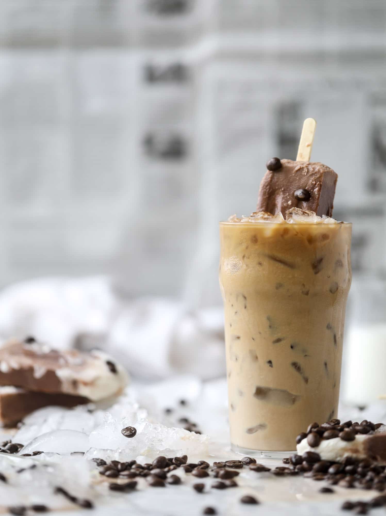 These fudgesicles are made with cold brew and dutch process cocoa for the most fun grown-up popsicle that can also deliver a little caffeine jolt. Topped with vanilla bean sweet cream, these are just like an iced latte in a pop! Serve as a treat or a snack! I howsweeteats.com #coldbrew #coffee #sweet #cream #popsicle #fudgesicle