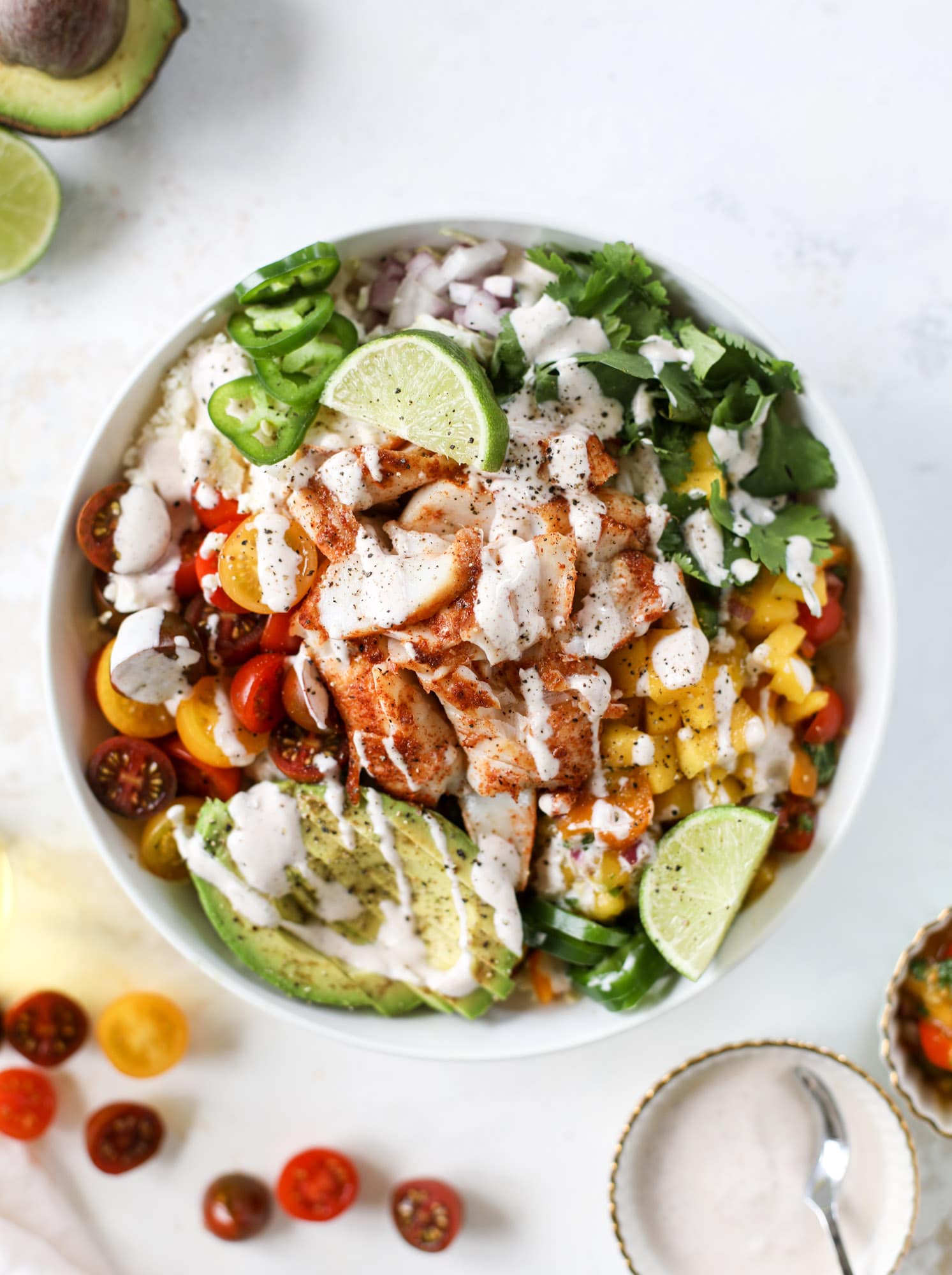 These fish taco bowls are an amazing weeknight meal idea! Napa cabbage for the base, a homemade chipotle crema, avocado, mango pico de gallo, spicy broiled white fish and lots of lime. Major flavor explosion and so easy too! I howsweeteats.com #fish #taco #bowls #spicy #healthy #dinner