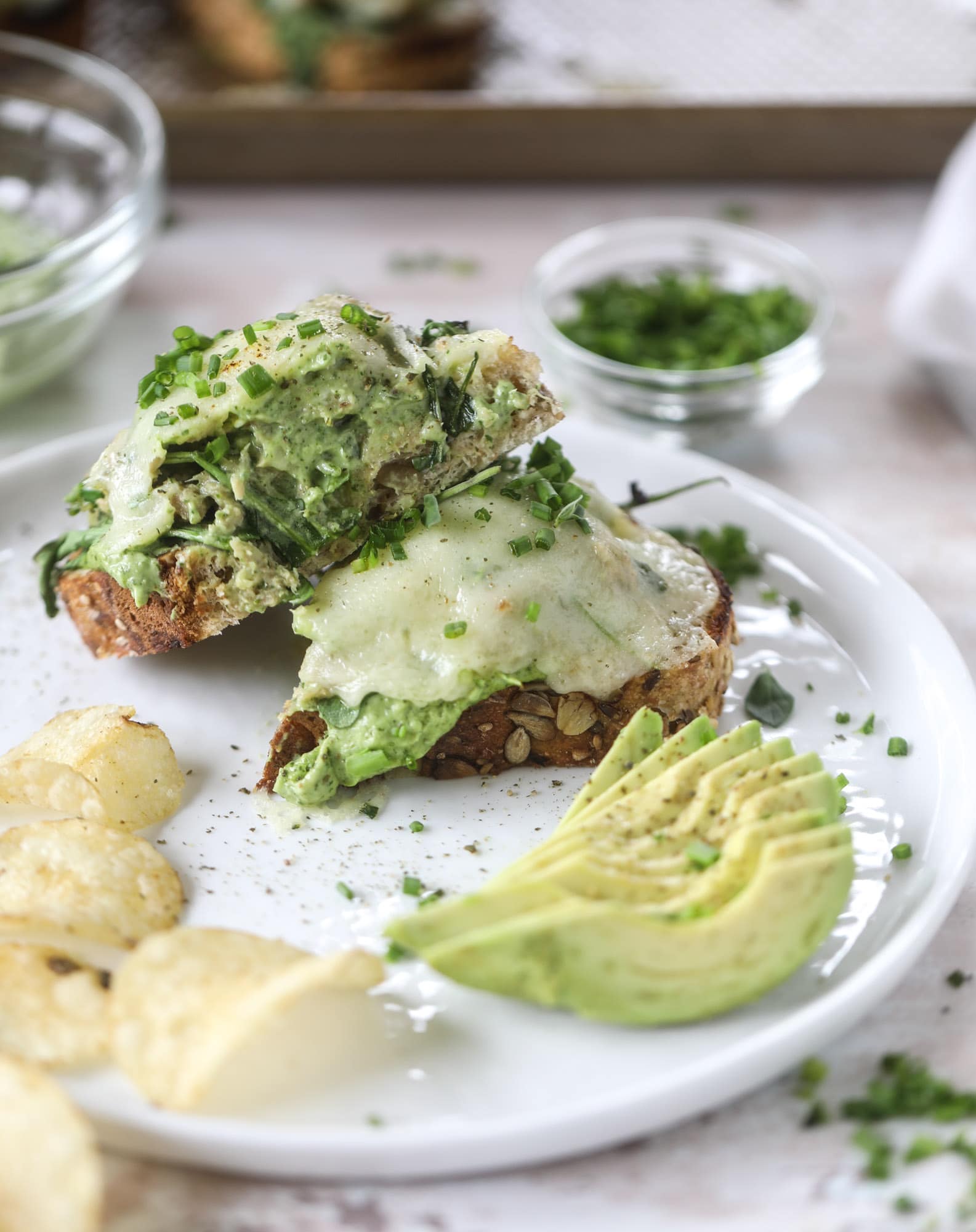 These green green tuna melt tartines are a lunch dream come true! The green goddess dressing is full of avocado, greek yogurt, spinach and fresh herbs. Paired with the tuna, whole grain toast and melty cheese, it's incredibly delicious and a super easy lunch! I howsweeteats.com #green #goddess #tune #salad #melts