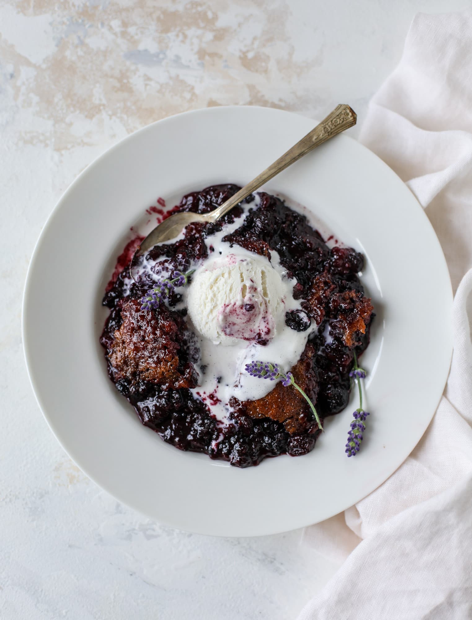 This black raspberry cobbler is a summer dream come true! The bursting black raspberries are rich and sweet, then add in a touch of lavender for incredible flavor and you're all set. The cobbler cake topping is perfect for vanilla ice cream. Win! I howsweeteats.com #black #raspberry #cobbler #lavender #summer #desserts #icecream