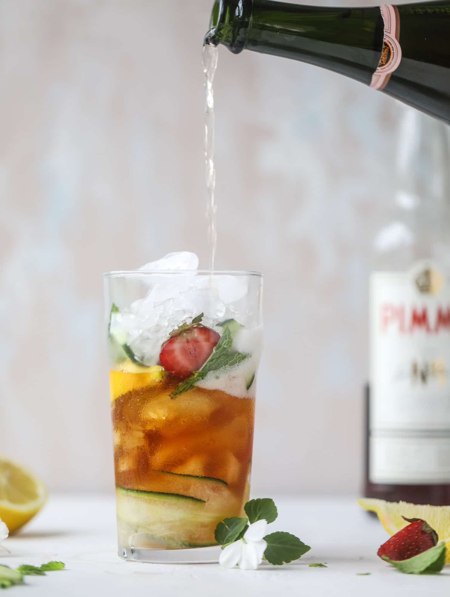 I love a delicious Pimm's Cup in the heart of summer! This was is topped with sparkling rosé wine and filled with strawberries, cucumbers and lemon wedges. It's super refreshing and perfect on hot hot days! I howsweeteats.com #pimms #cup #recipe #cocktails #rosé #sparkling #summer