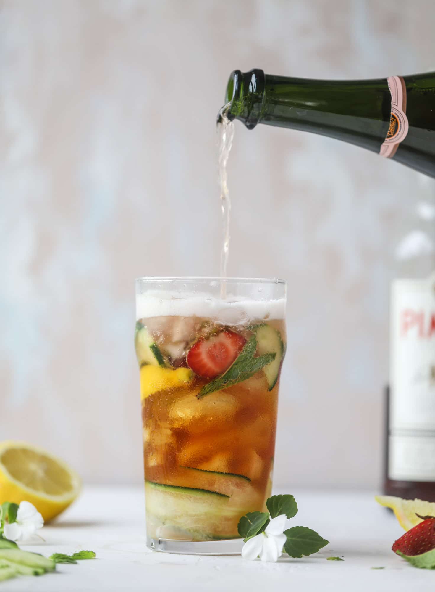 I love a delicious Pimm's Cup in the heart of summer! This was is topped with sparkling rosé wine and filled with strawberries, cucumbers and lemon wedges. It's super refreshing and perfect on hot hot days! I howsweeteats.com #pimms #cup #recipe #cocktails #rosé #sparkling #summer