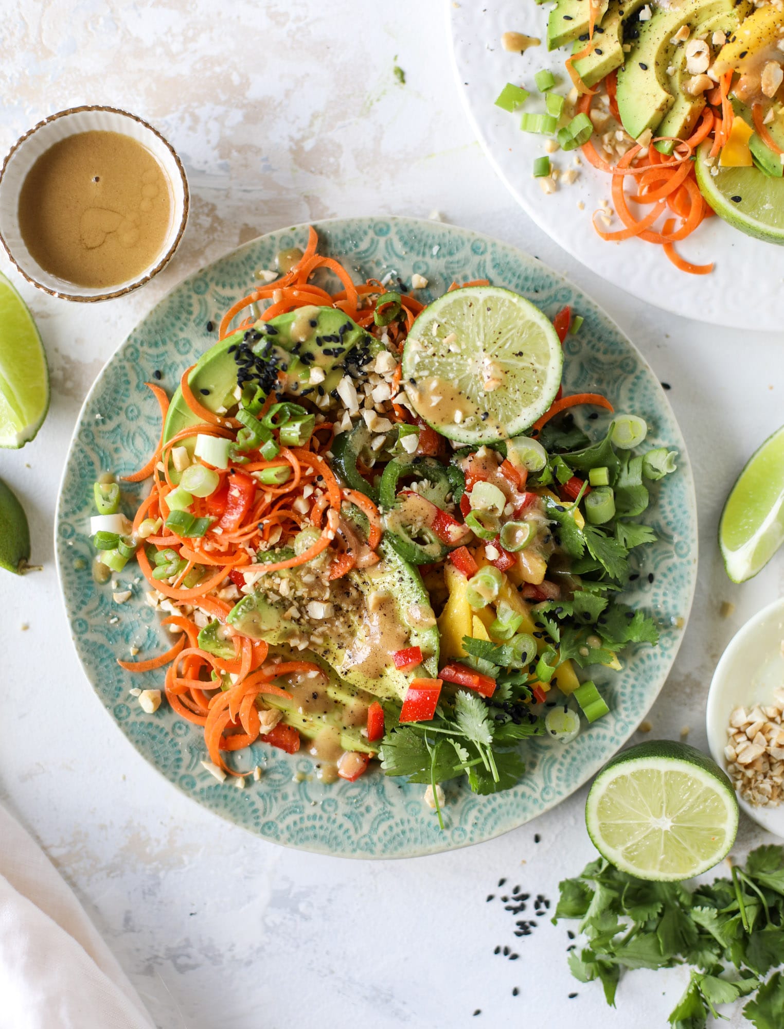 This thai avocado salad is loaded with mango, red pepper, carrots, green onions and drizzled with a peanut butter vinaigrette. It's an amazing side salad or a fabulous dinner salad - add on chickpeas or shrimp or chicken if you wish! I howsweeteats.com #thai #avocado #salad #peanutbutter #mango #lime
