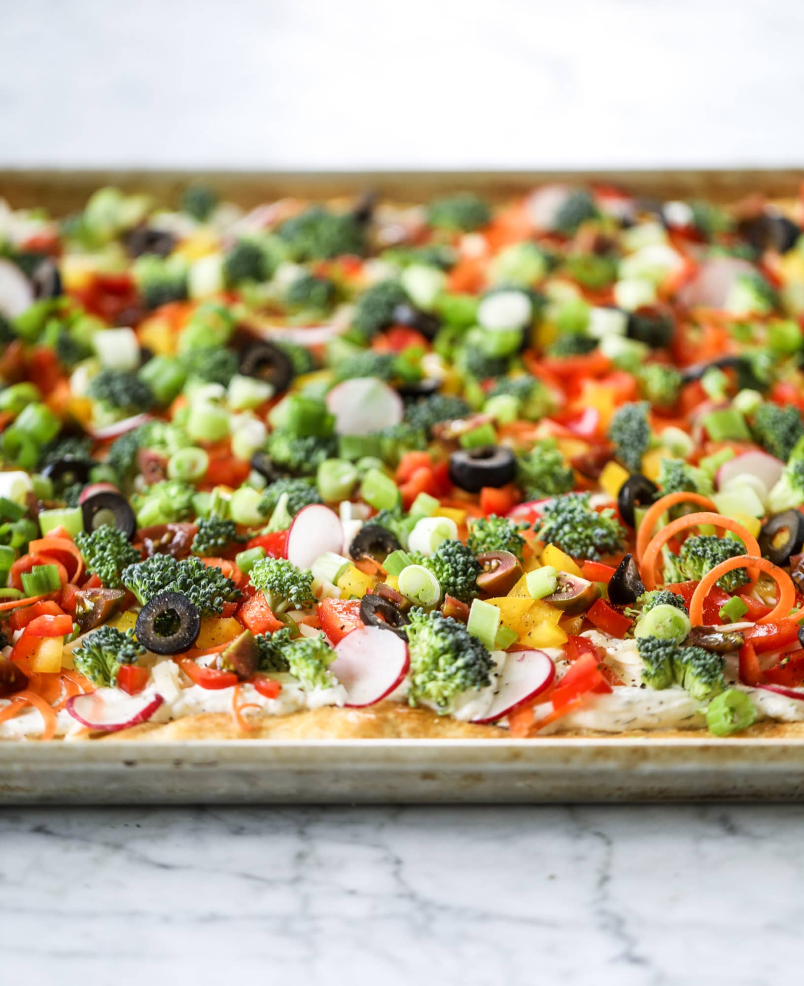 My mom's classic appetizer, the old school veggie pizza, is perfect for summer parties both indoor and out! A flaky pastry crust, a flavorful mascarpone greek yogurt base and tons of fresh chopped vegetables on top. It's a winning combination! I howsweeteats.com #veggie #pizza #appetizer #summer #crescentrolls #greekyogurt
