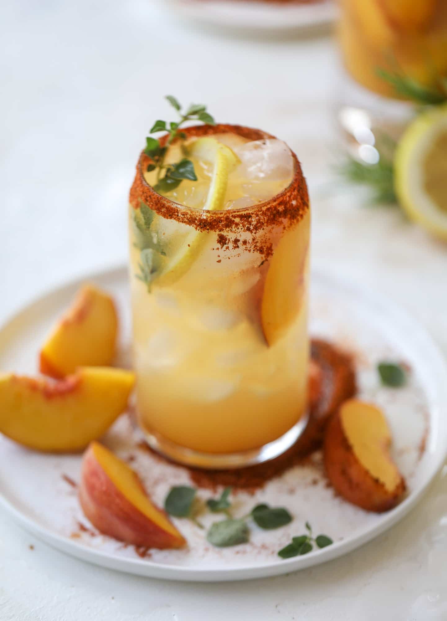 This peach lemonade is super refreshing and a bit spicy for a hot and sunny summer day. It's sweet and fresh and the rim is dipped in a cajun seasoning, bringing the best bite of heat to this perfect summer drink. So fresh! I howsweeteats.com #peach #lemonade #cajun #summer #mocktail #lemon #drink