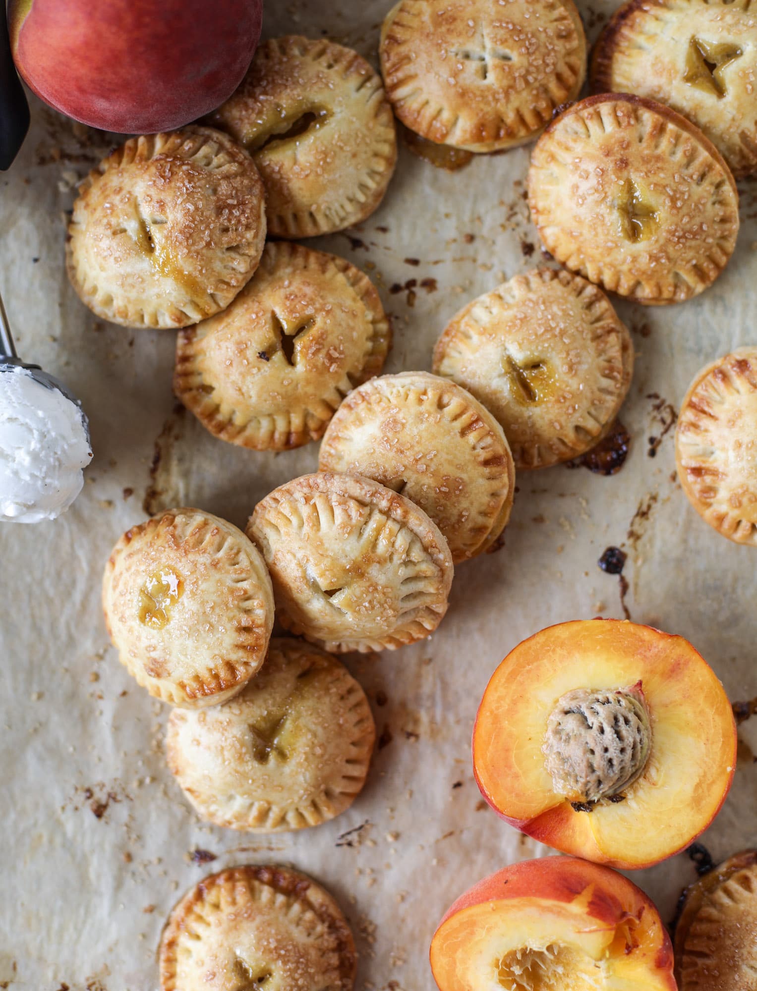 These little peach hand pies are super easy to make and oh-so delicious for summer! A warm and syrupy homemade peach filling made with brown sugar and bourbon, stuck inside a flakey all-butter crust and sprinkled with coarse sugar. SO GOOD. I howsweeteats.com #peach #hand #pies #mini #dessert #summer