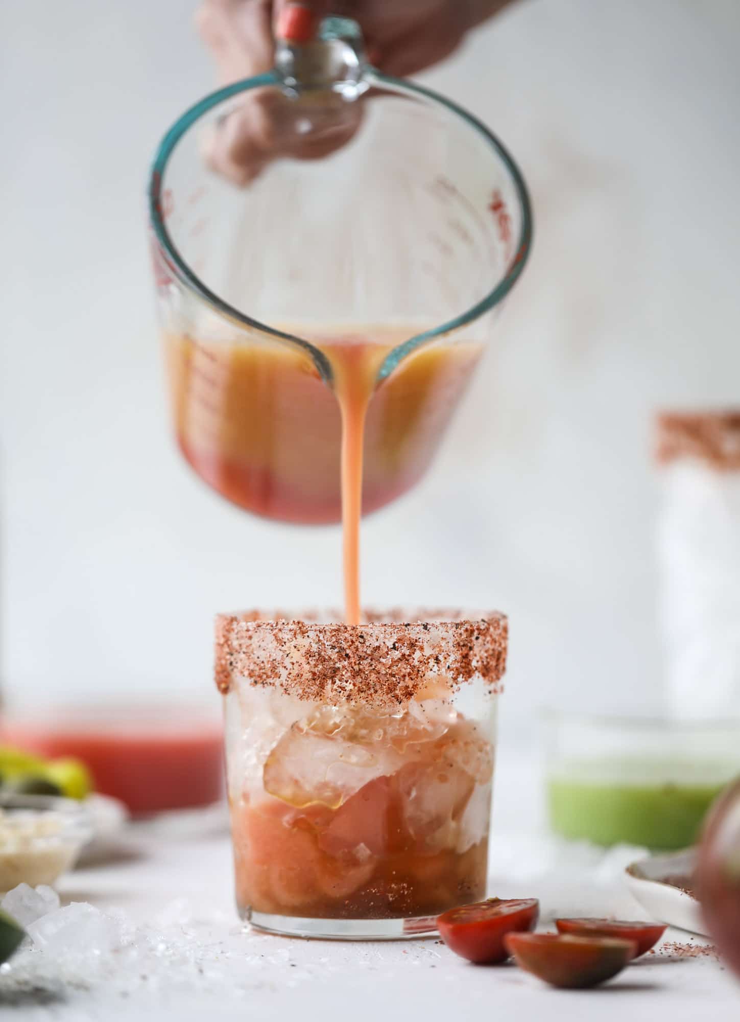This bloody mary recipe is made with fresh heirloom tomatoes - the gems of summer! The colors swirl together to create a stunning drinking that is loaded with smoky, spicy flavor. Top with your favorite snacks foe the perfect brunch! I howsweeteats.com #bloody #mary #recipe #best #heirloom #tomatoes #cocktail