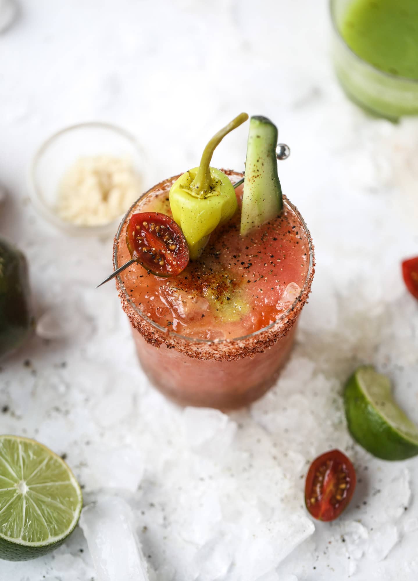 This bloody mary recipe is made with fresh heirloom tomatoes - the gems of summer! The colors swirl together to create a stunning drinking that is loaded with smoky, spicy flavor. Top with your favorite snacks foe the perfect brunch! I howsweeteats.com #bloody #mary #recipe #best #heirloom #tomatoes #cocktail