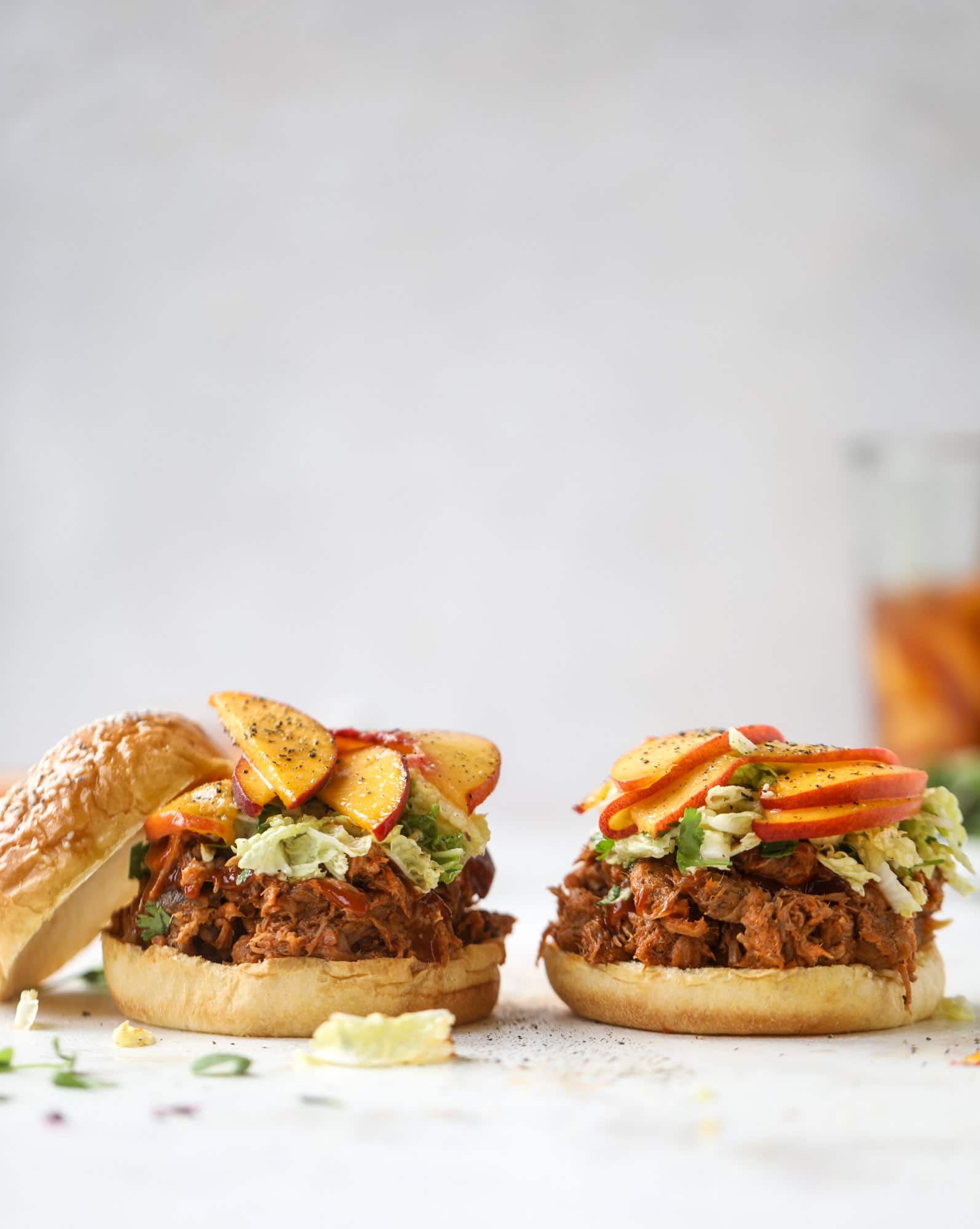 This chipotle pulled pork sandwich is spicy, sweet and saucy. Throw it on a bun or a plate and top it with the most delicious quick pickled peaches and napa cabbage slaw. Flavor and texture make this sandwich incredible! I howsweeteats.com #pulled #pork #chipotle #pickled #peaches #slaw #sandwiches #slow #cooker