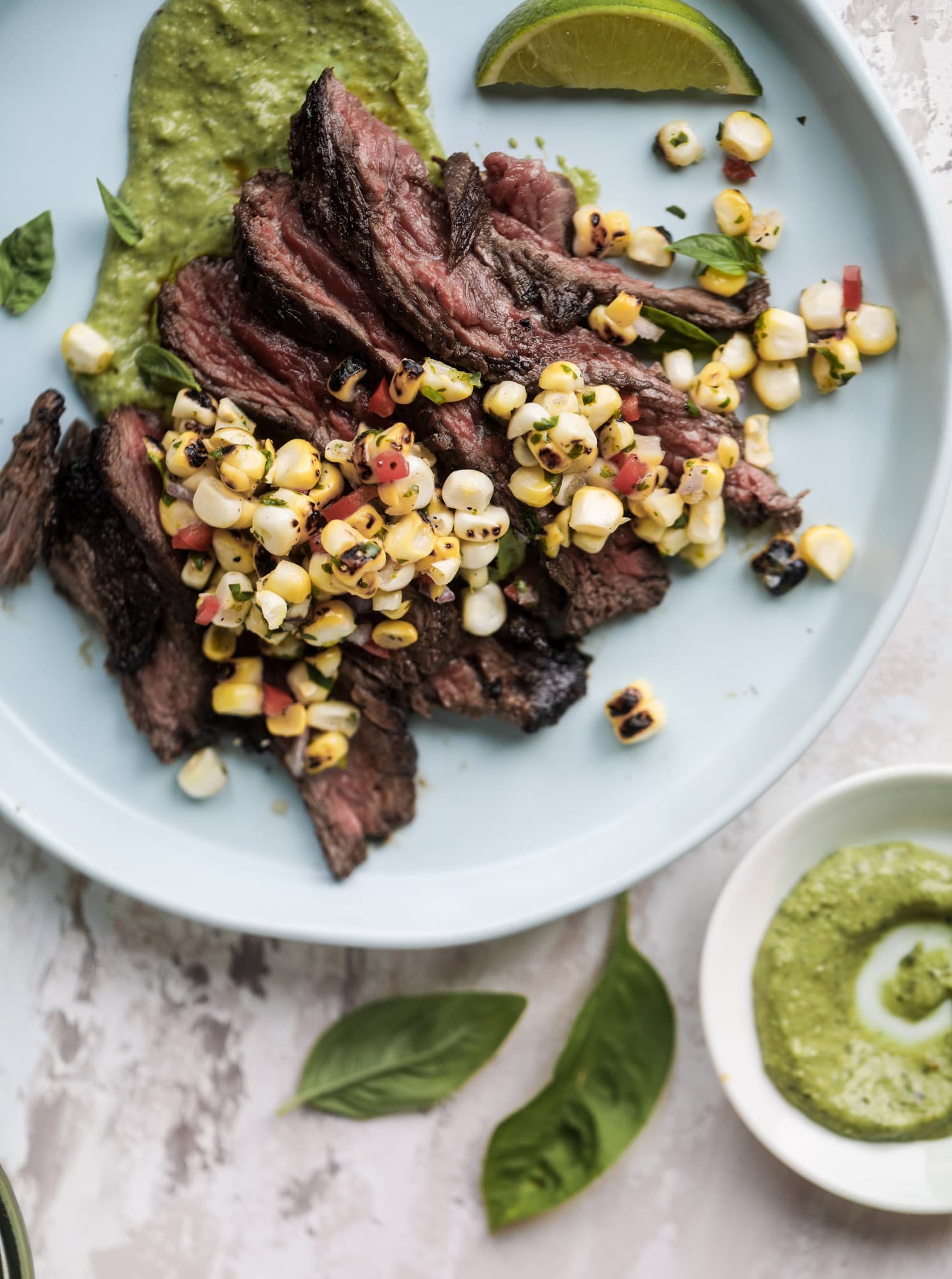This skirt steak recipe is so super easy and delicious! Marinate it for a bit, prepare it to your liking then serve it with the most flavorful avocado pesto and grilled corn relish. Feels like a fancy restaurant meal and will make you love skirt steak forever! I howsweeteats.com #skirt #steak #avocado #pesto #corn #relish #recipes
