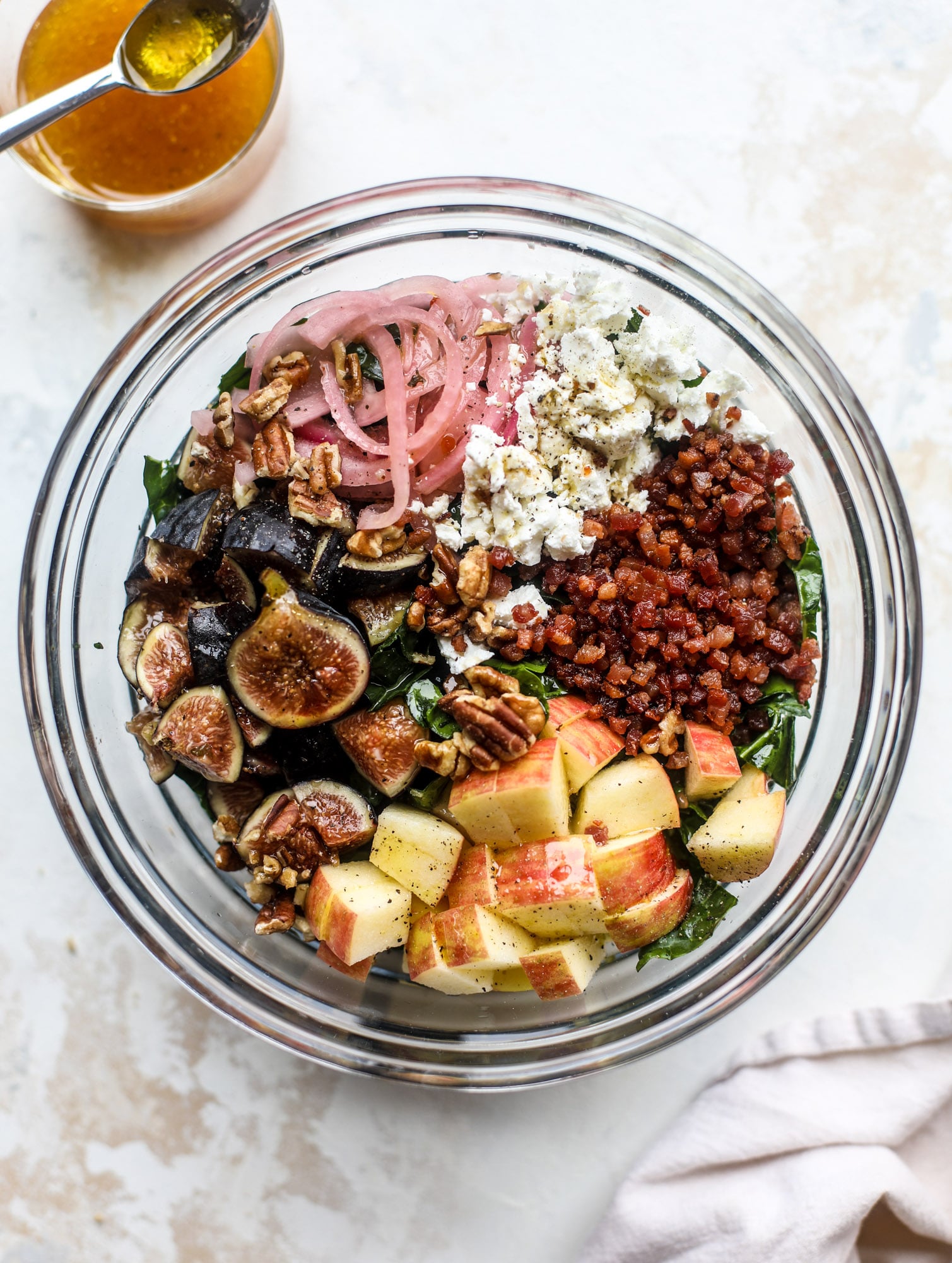 This fall kale salad is perfect for the season and full of so much delicious flavor! Shredded kale, honeycrisp apple, fresh figs, pancetta, pickled onions, pecans and goat cheese come together with a maple cider vinaigrette for salad heaven. I howsweeteats.com #fall #kale #salad #apples #figs #pecans