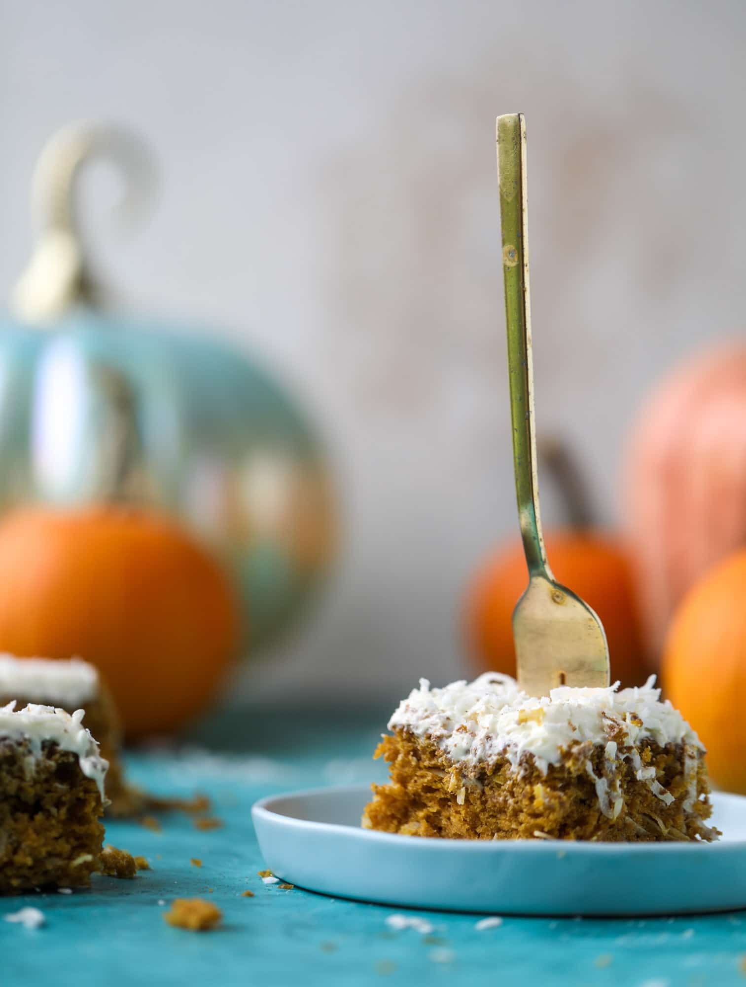 This pumpkin coconut cake is super tender and delicious and comes together quickly in a baking dish! It's spiced for the season and covered in a fluffy coconut cream cheese frosting. You can made it ahead of time for a crowd and it's a huge hit! I howsweeteats.com #pumpkin #cake