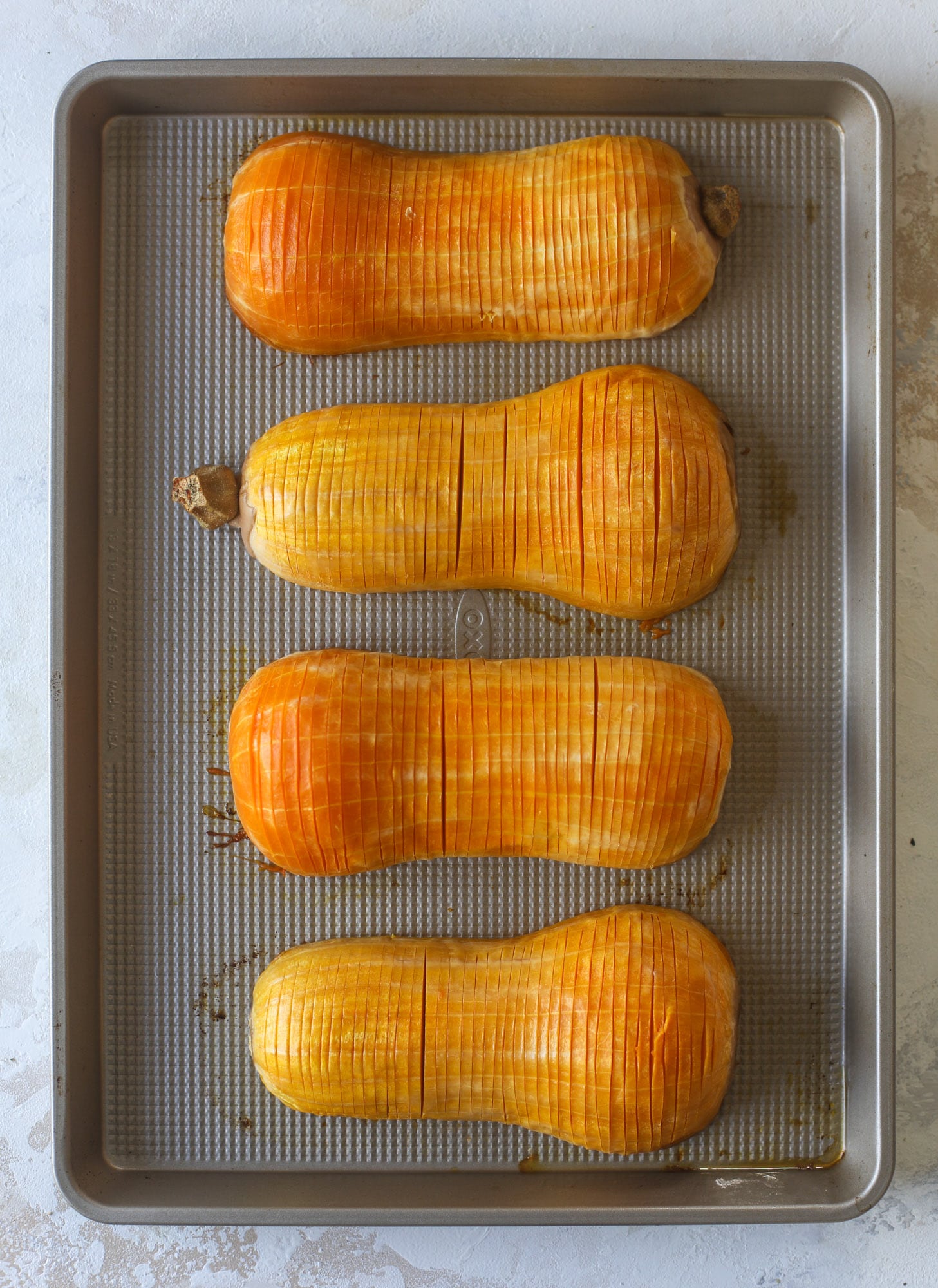 This hasselback butternut squash is perfect for Thanksgiving - and you can easily make it two ways! We have a maple pecan hassleback butternut squash and a brown butter sage hasselback butternut squash. Delicious! I howsweeteats.com #hasselback #butternutsquash