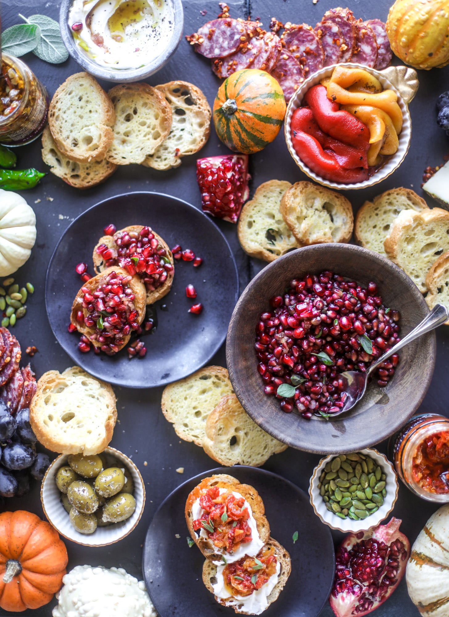 This is the perfect autumn harvest bruschetta board to feed a crowd or serve at a party! The standout is pomegranate relish with a cinnamon shallot vinaigrette, lots of toasty bread, bruschettas, cheese and olives. Everything that's delish! I howsweeteats.com #bruschetta #board
