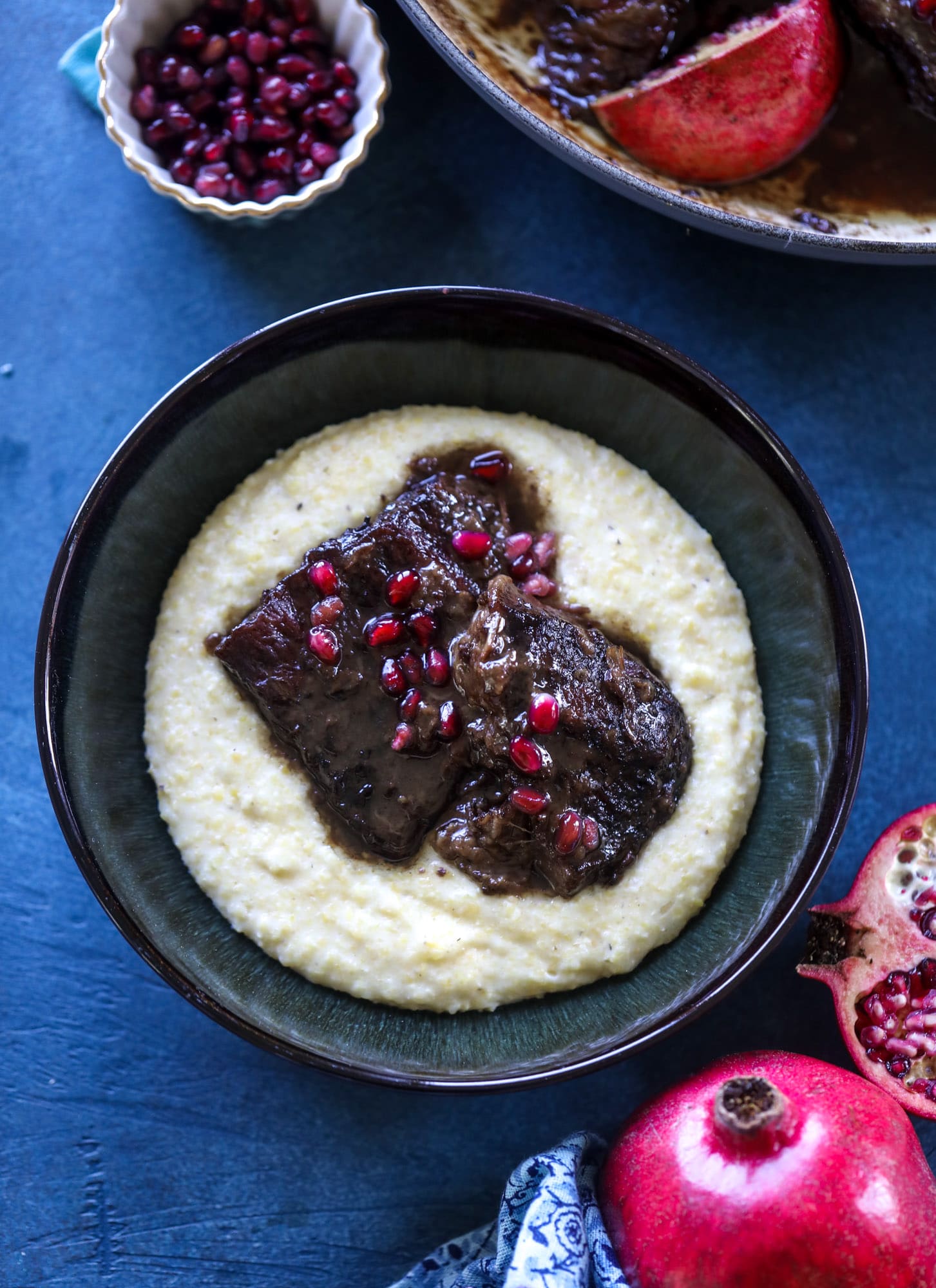 These pomegranate braised short ribs are an incredible take on comfort food! Pomegranate juice and molasses are the base of the recipe and after braising, you're left with tender, juicy and flavorful beef that is amazing served with polenta, potatoes or even in tacos. I howsweeteats.com #braised #shortribs