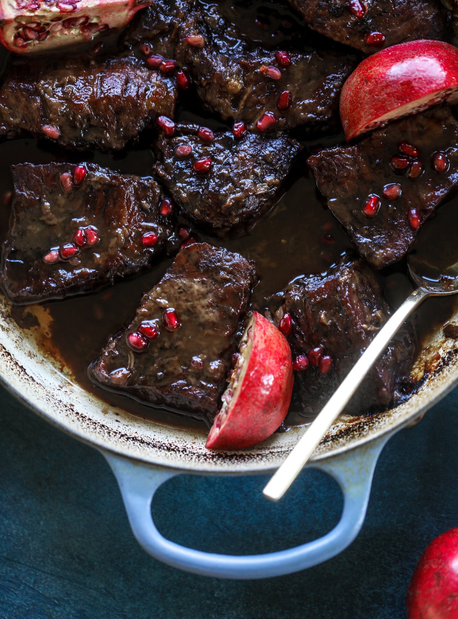 These pomegranate braised short ribs are an incredible take on comfort food! Pomegranate juice and molasses are the base of the recipe and after braising, you're left with tender, juicy and flavorful beef that is amazing served with polenta, potatoes or even in tacos. I howsweeteats.com #braised #shortribs