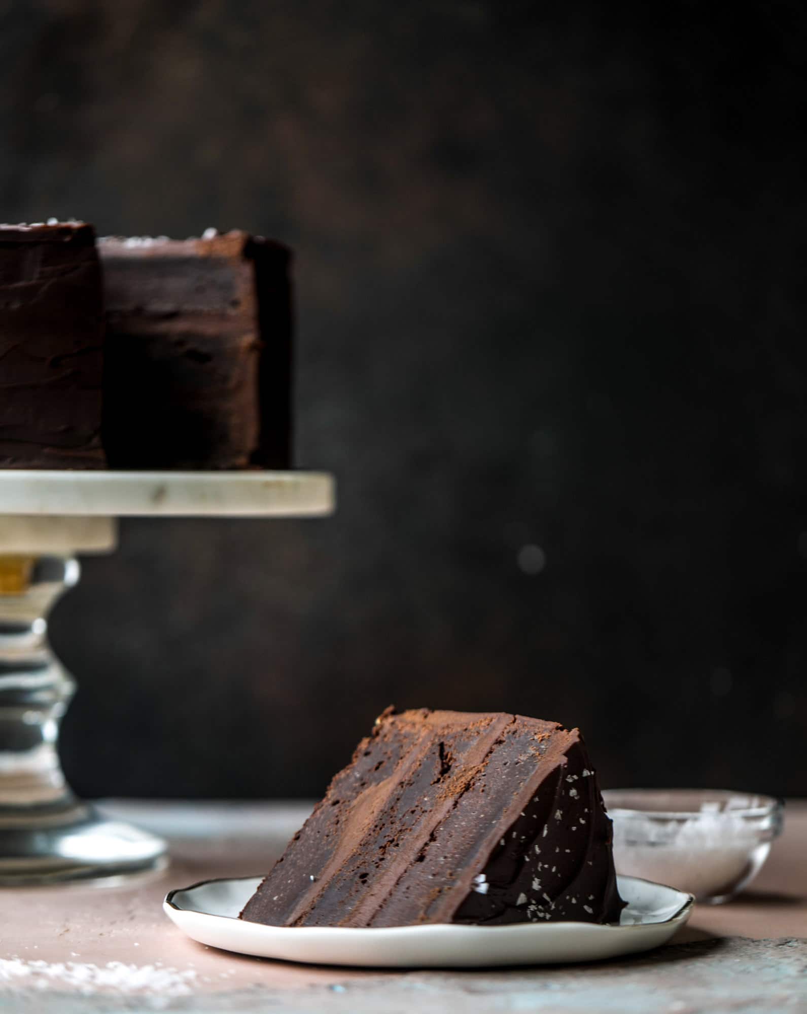 This salted dark chocolate stout cake is absolutely divine! It's ridiculously rich and perfect for a crowd or a party. Pumpkin stout batter is baked into fluffy laters and covered in a super fudgy chocolate ganache. Perfect for chocolate lovers! I howsweeteats.com #dark #chocolate #stout #cake #salted