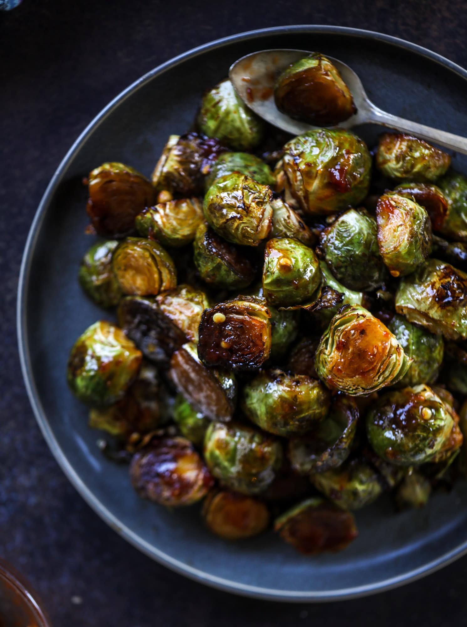 These sweet and spicy brussels sprouts are roasted to perfect and the most delicious side dish! It's a great way to elevate regular old brussels sprouts and make a fantastic side to to serve on a weeknight! I howsweeteats.com #spicy #brusselssprouts