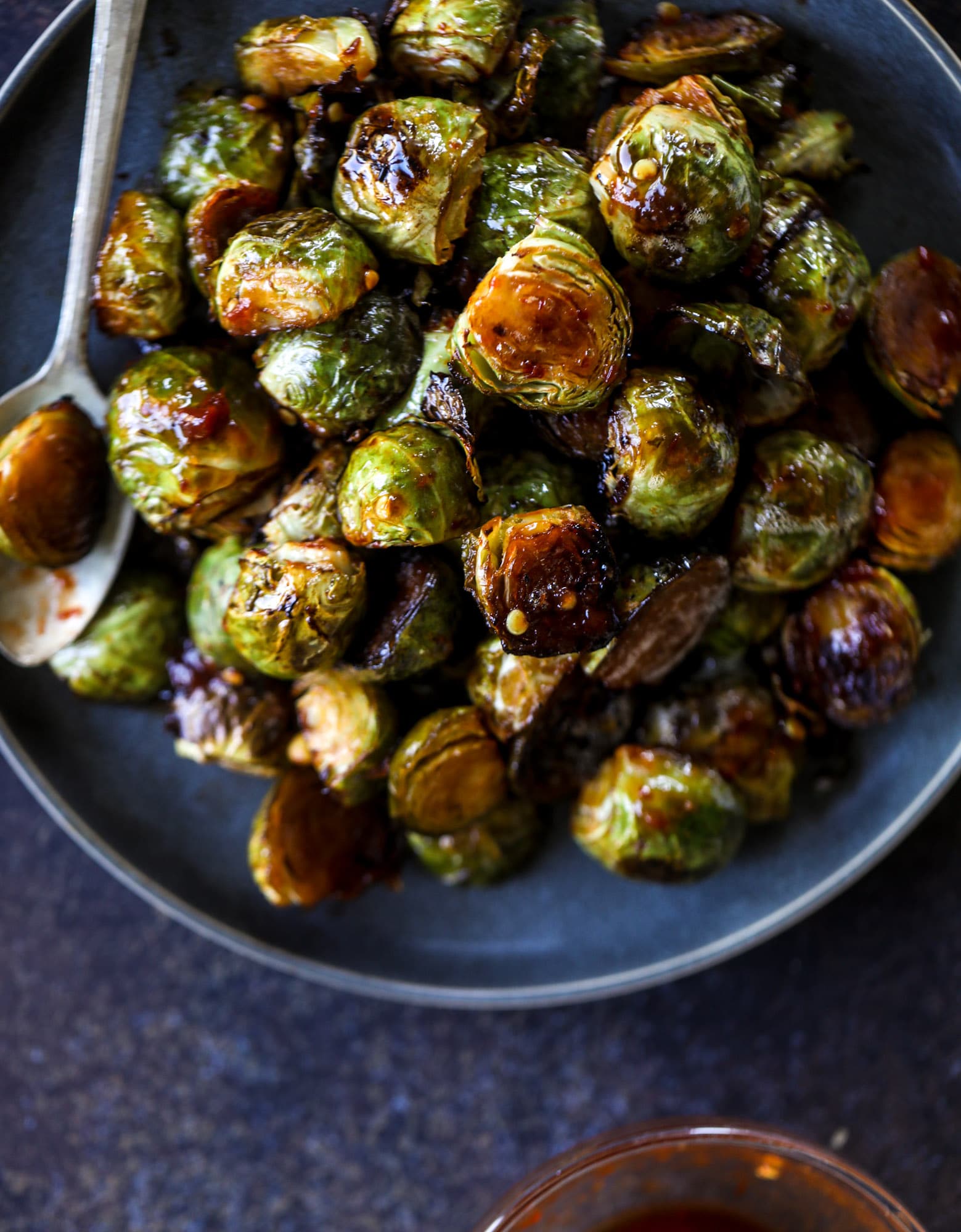 These sweet and spicy brussels sprouts are roasted to perfect and the most delicious side dish! It's a great way to elevate regular old brussels sprouts and make a fantastic side to to serve on a weeknight! I howsweeteats.com #spicy #brusselssprouts