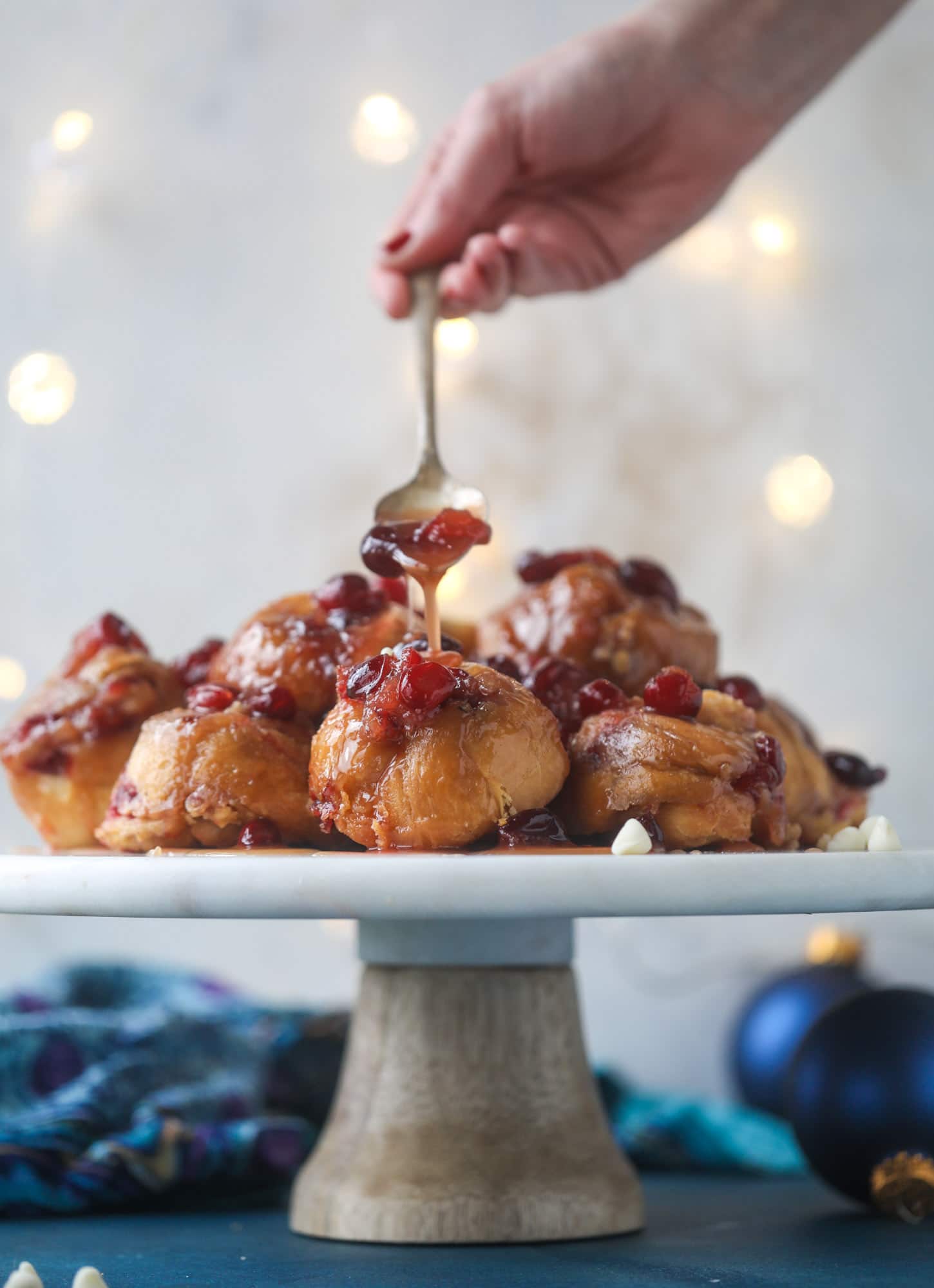 These white chocolate cranberry sticky buns are what holiday dreams are made of! Made in a muffin tin with fresh cranberries and creamy white chocolate, they are drizzled with cranberry caramel too! Dreamy! I howsweeteats.com #sticky #buns