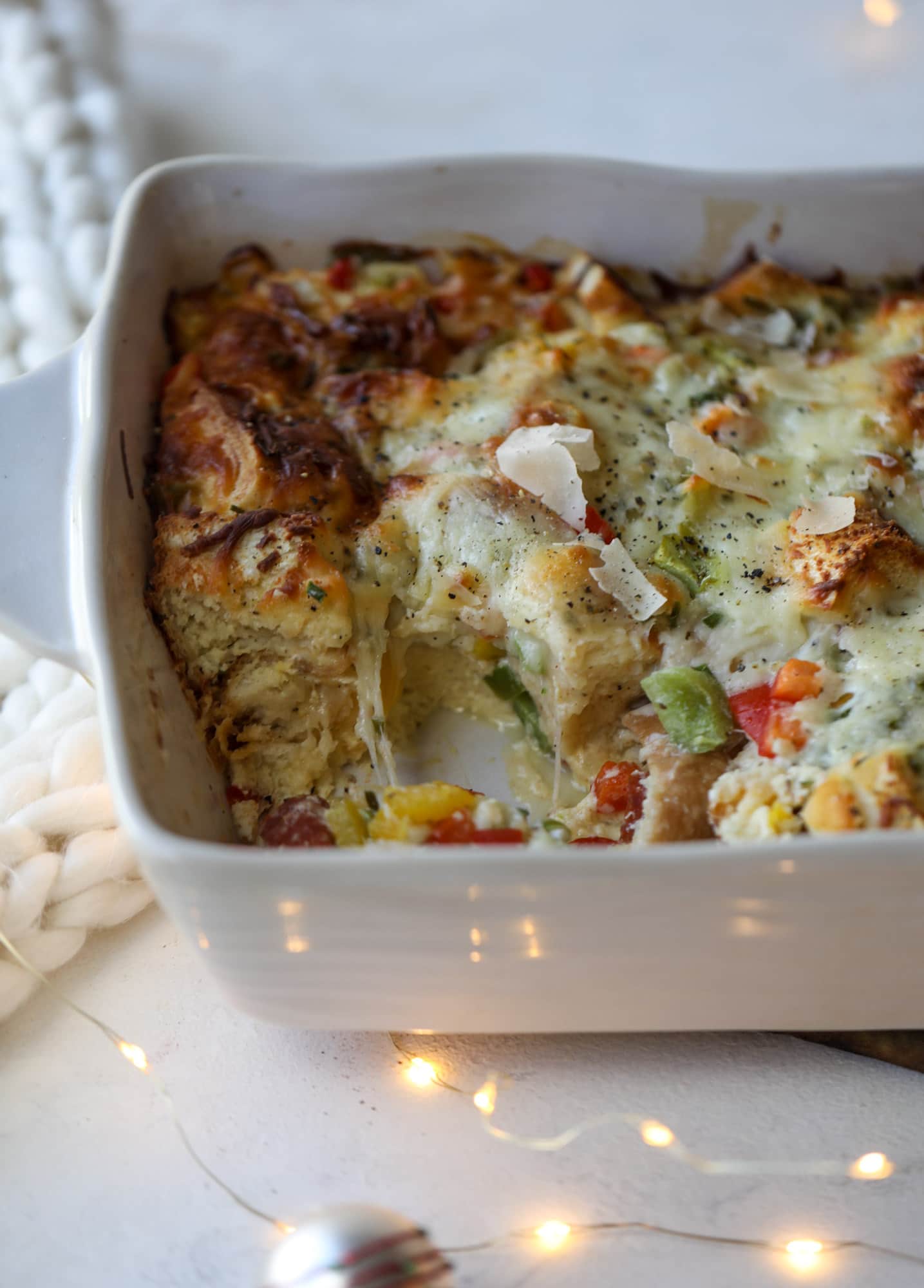 This breakfast strata is super special because the base is built on pepperoni rolls! This make ahead casserole is perfect for holiday brunches or parties and tastes like a supreme pizza. It's so easy to throw together too! I howsweeteats.com #breakfast #strata