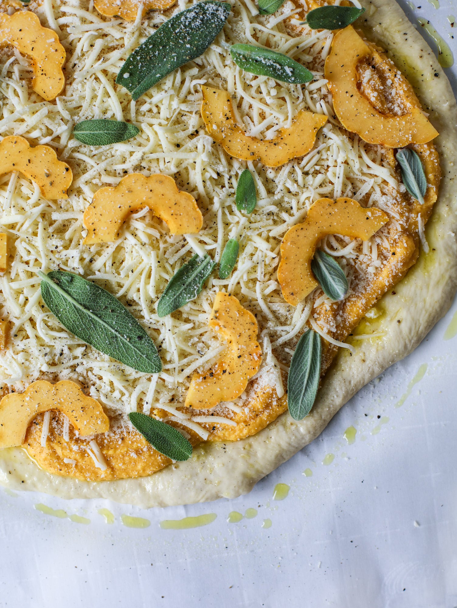 This butternut squash pizza has all the perfect tastes of fall in a pizza! Creamy butternut squash base, sharp parmesan cheese, crispy, fresh sage - it's all these and so super flavorful. It's easy too! I howsweeteats.com #butternutsquash #pizza