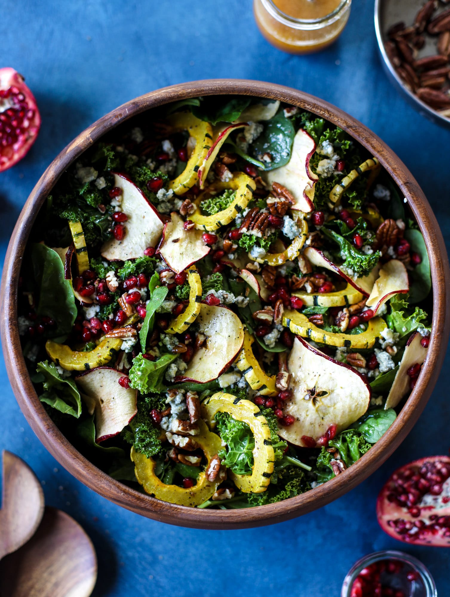 This thanksgiving salad is full of so much autumn flavor. It has toasted pomegranate, delicata squash, toasted pecans, creamy blue cheese and crunchy apple chips. It's light enough to serve before the big meal! I howsweeteats.com #thanksgiving #salad