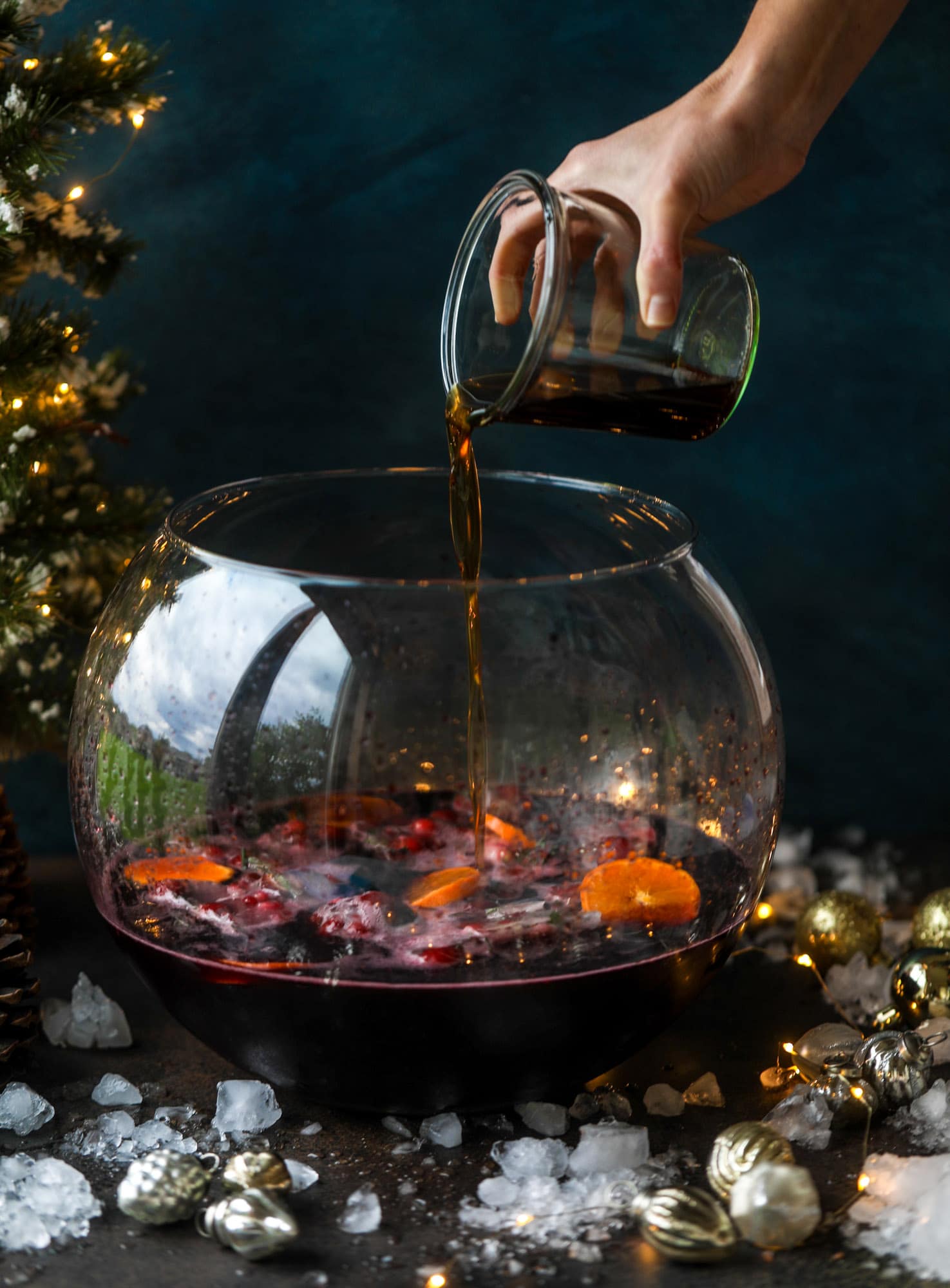 This tree trimming punch is the most perfect christmas punch to drink while decorating the tree! Rich red wine is the base and there's a bit of orange, some spice, cinnamon and a gorgeous jeweled holiday ice cubes! I howsweeteats.com #christmas #punch