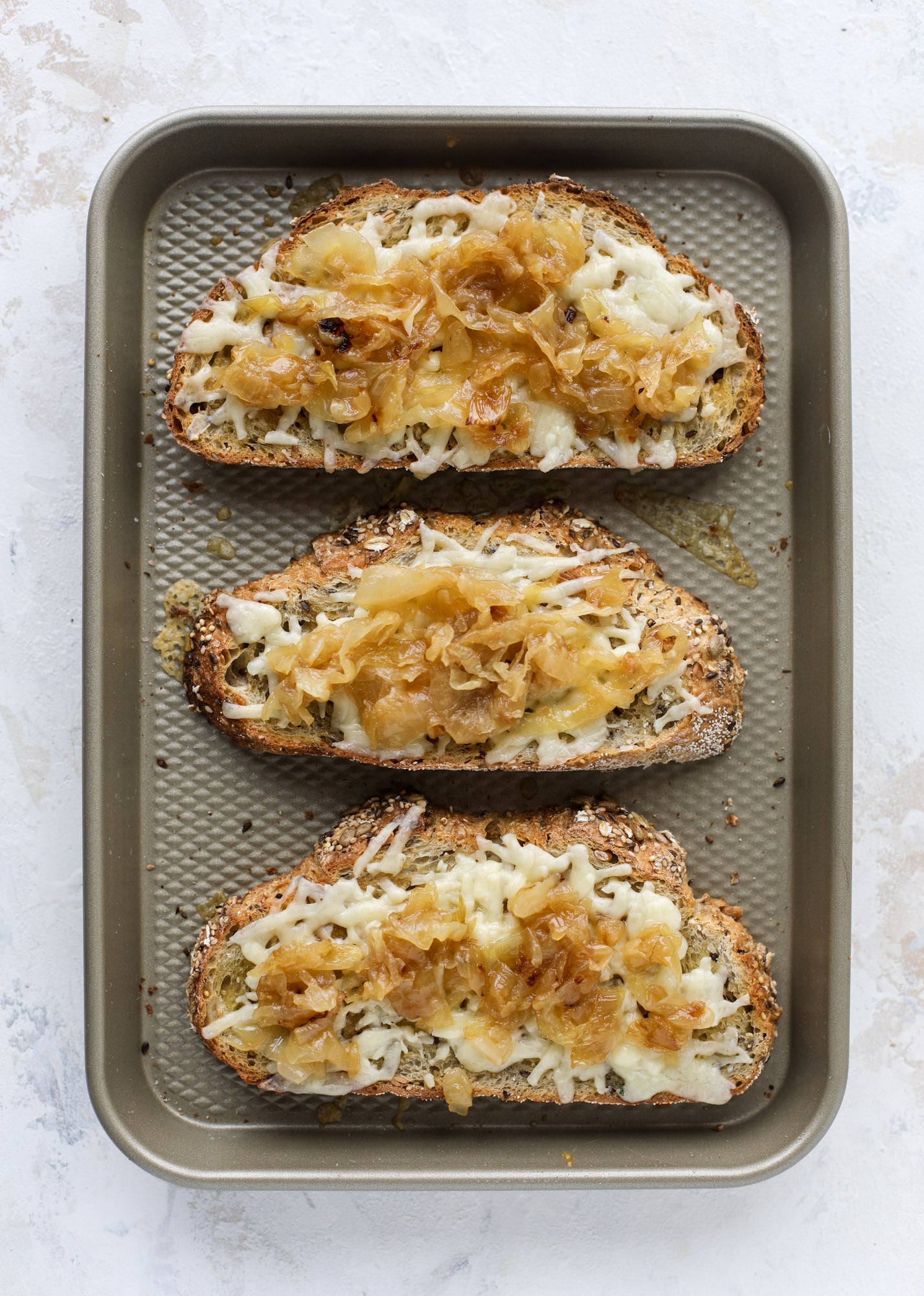 Crispy brussels sprouts toast begins with sourdough bread, melty havarti cheese and caramelized onions. It's high-maintenance toast in the best way possible. I howsweeteats.com