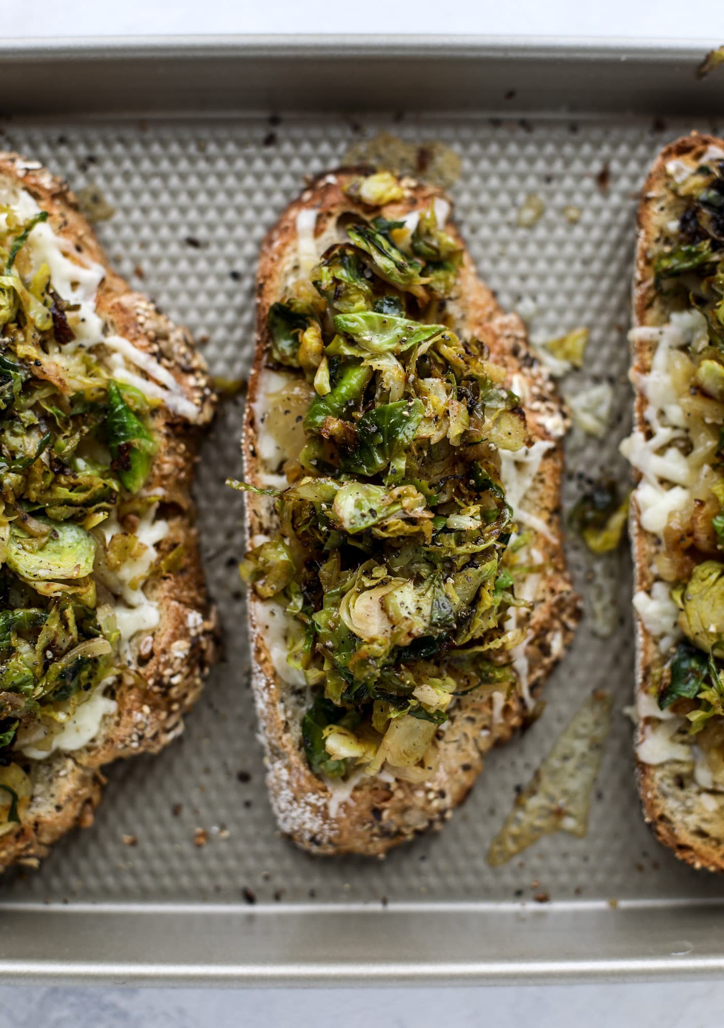 Crispy brussels sprouts toast begins with sourdough bread, melty havarti cheese and caramelized onions. It's high-maintenance toast in the best way possible. I howsweeteats.com