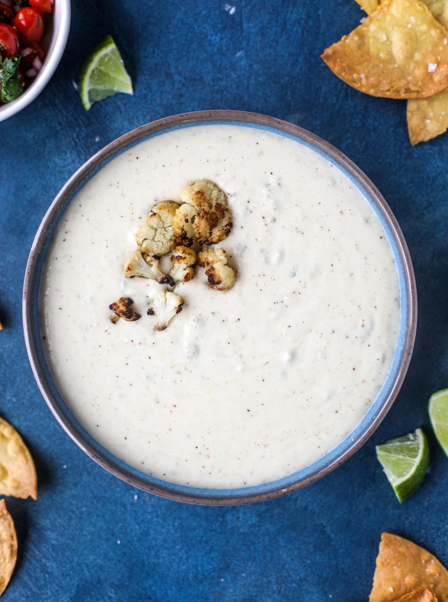 This roasted cauliflower queso has all the deliciousness of regular queso, with roasted cauliflower added in. It's satisfying and tastes like heaven. I howsweeteats.com #cauliflower #queso