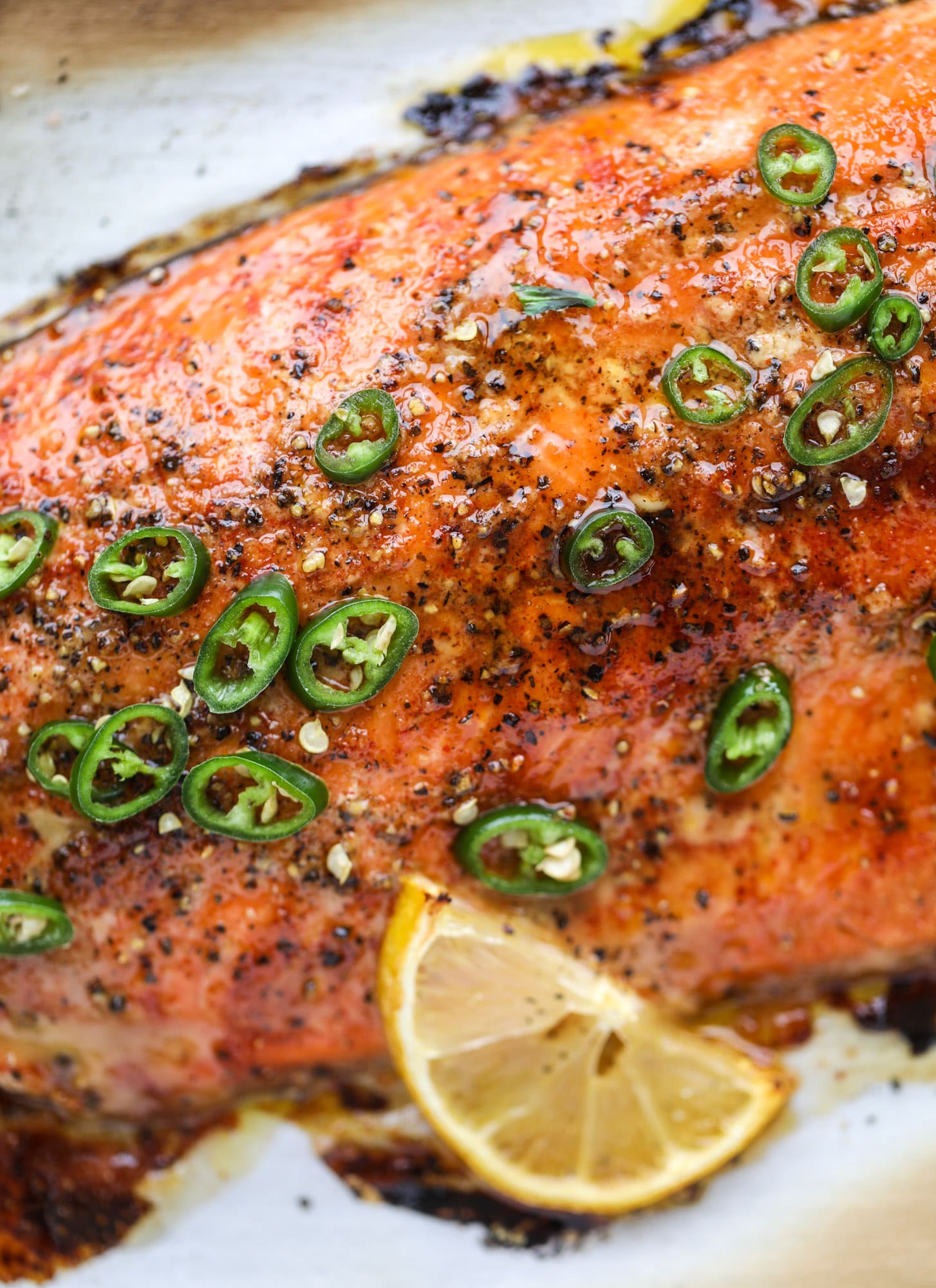 This hot honey salmon is flakey and buttery with a hint of heat and a sprtiz of lemon. It's an easy weeknight meal and is delicious on salads for lunch! I howsweeteats.com #hothoney #salmon