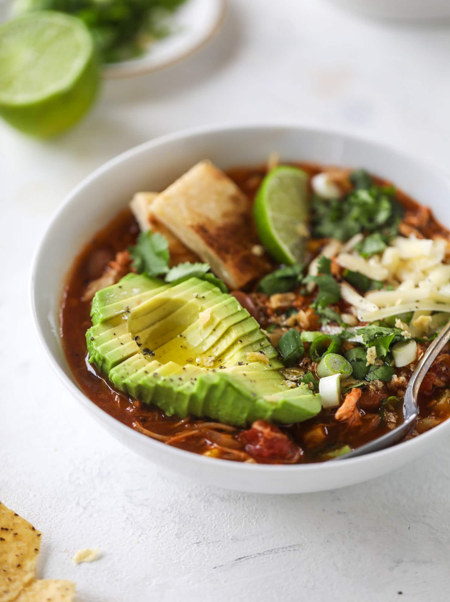 This flavorful chicken taco soup can be made on the stovetop or in the slow cooker. It's hearty and topped with cheese quesadilla croutons! I howsweeteats.com #chicken #tacosoup