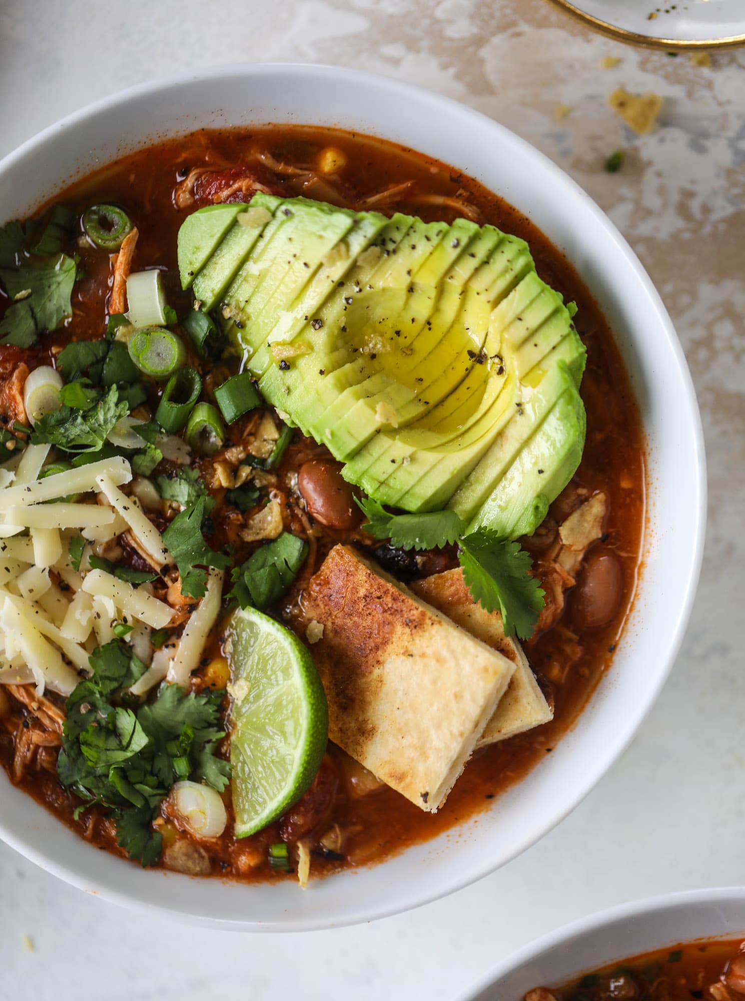 This flavorful chicken taco soup can be made on the stovetop or in the slow cooker. It's hearty and topped with cheese quesadilla croutons! I howsweeteats.com #chicken #tacosoup