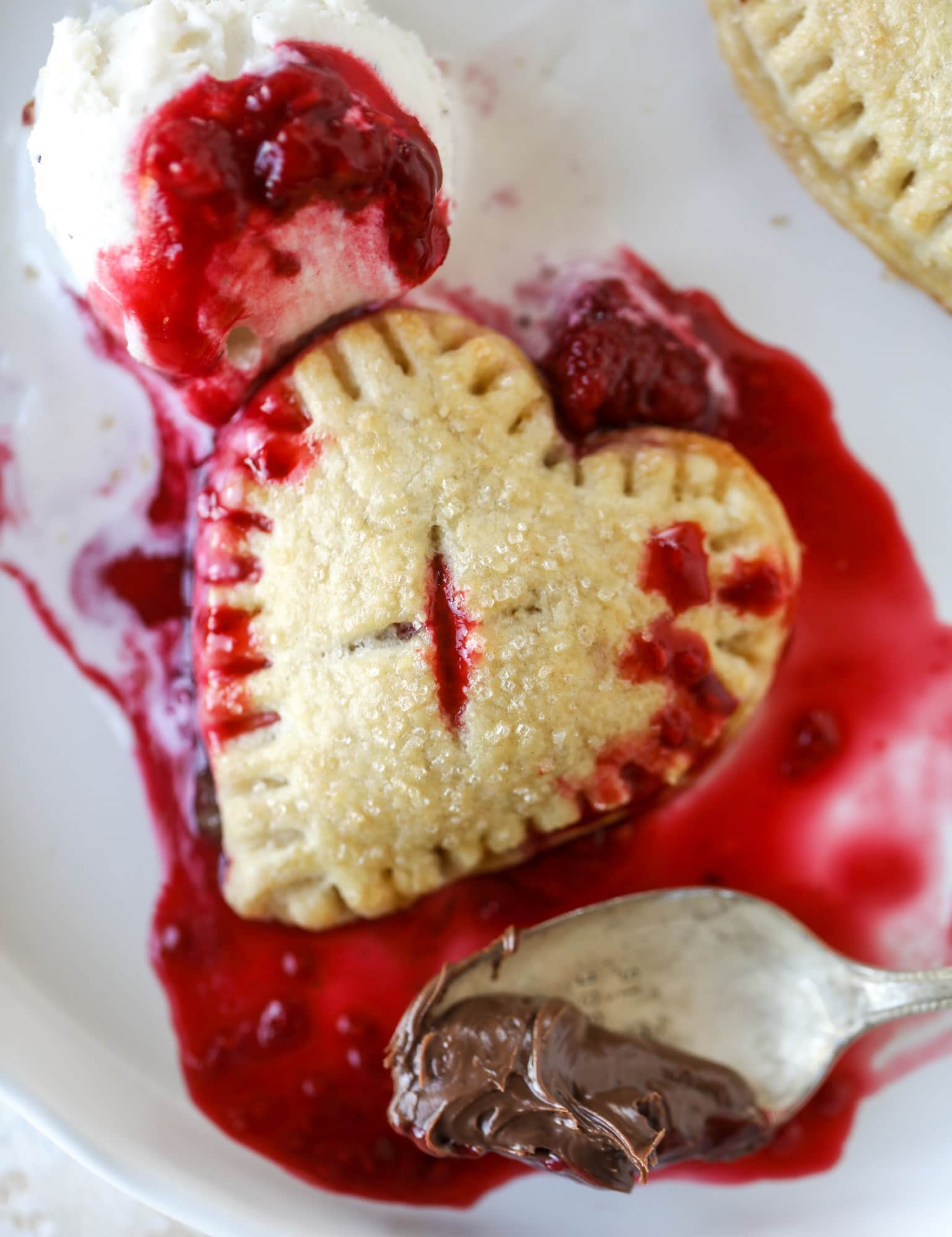 These adorable mini heart pies are filled with a homemade raspberry compote and creamy, chocolatey nutella. So fun and easy to make! I howsweeteats.com #heart #pie