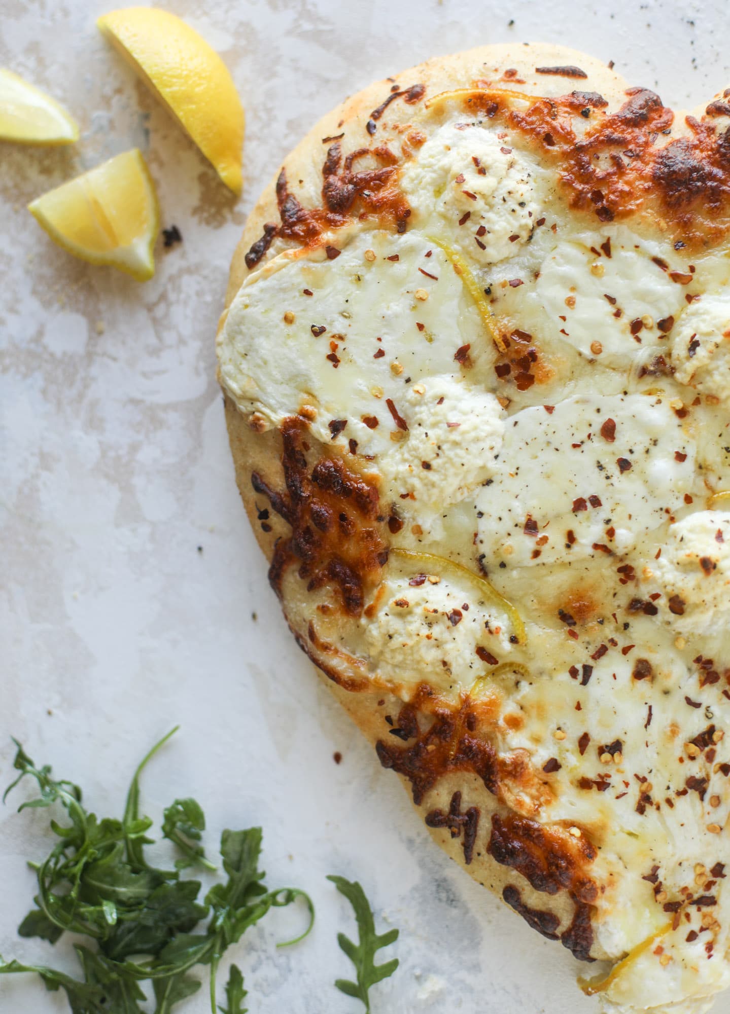 Our favorite white pizza recipe has four different kinds of cheese and comes on a garlic bread crust! Topped with crushed pepper and lemon - tons of flavor! I howsweeteats.com #white #pizza