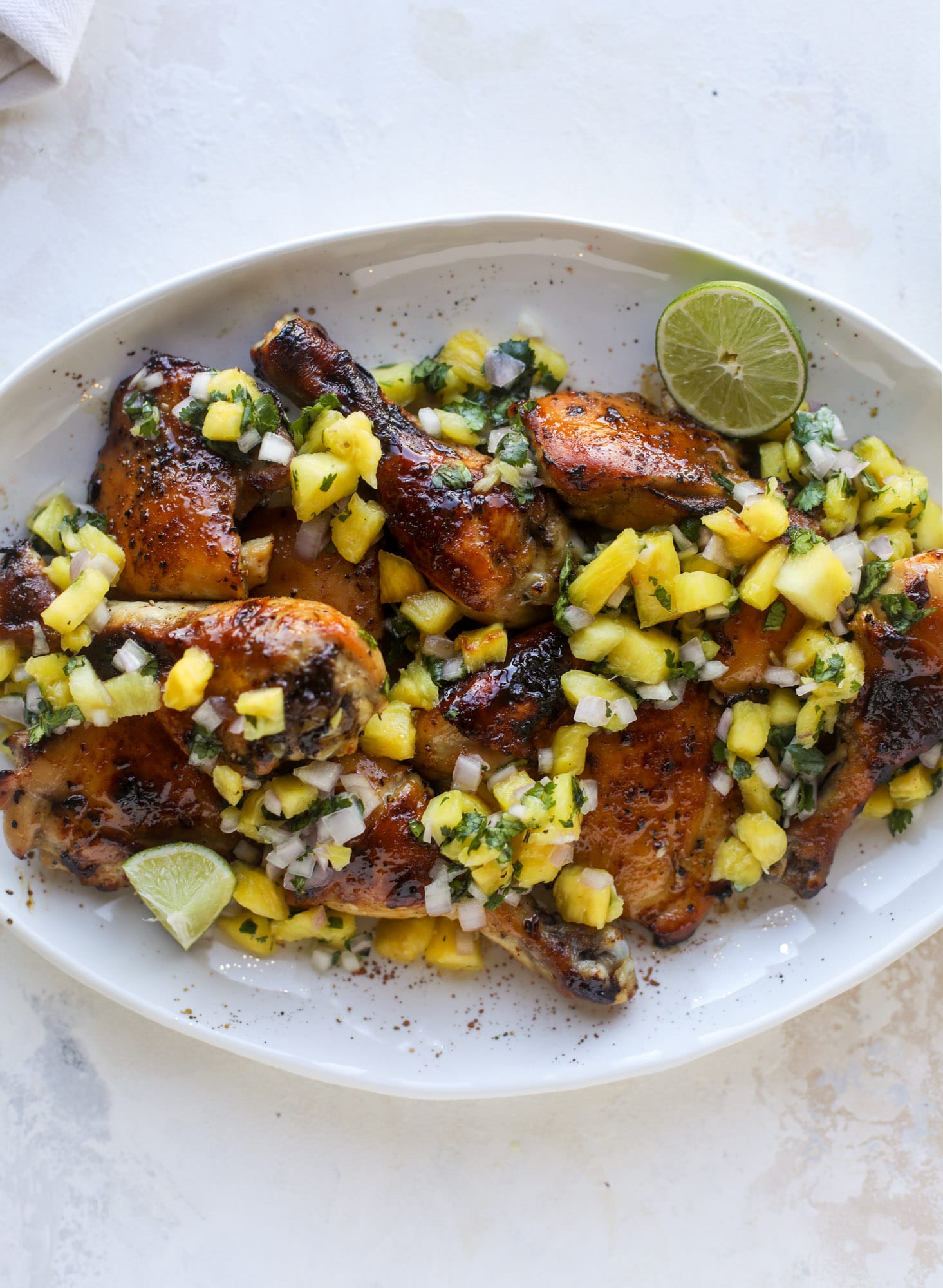 This sticky chicken recipe is made on a sheet pan and roasted until flavorfor and sticky with sauce, then served with pineapple salsa. It's the best! I howsweeteats.com #sticky #chicken