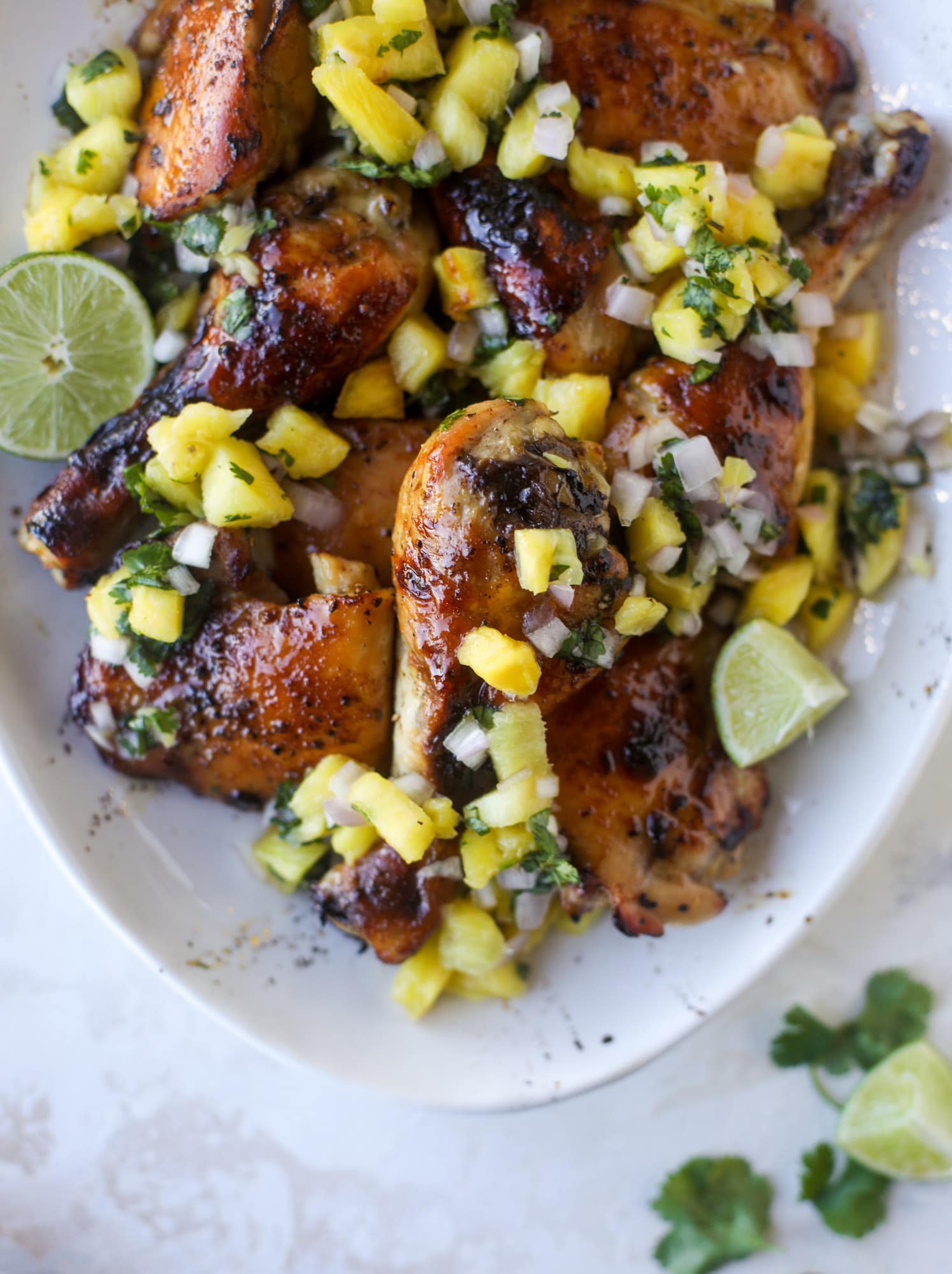 This sticky chicken recipe is made on a sheet pan and roasted until flavorfor and sticky with sauce, then served with pineapple salsa. It's the best! I howsweeteats.com #sticky #chicken