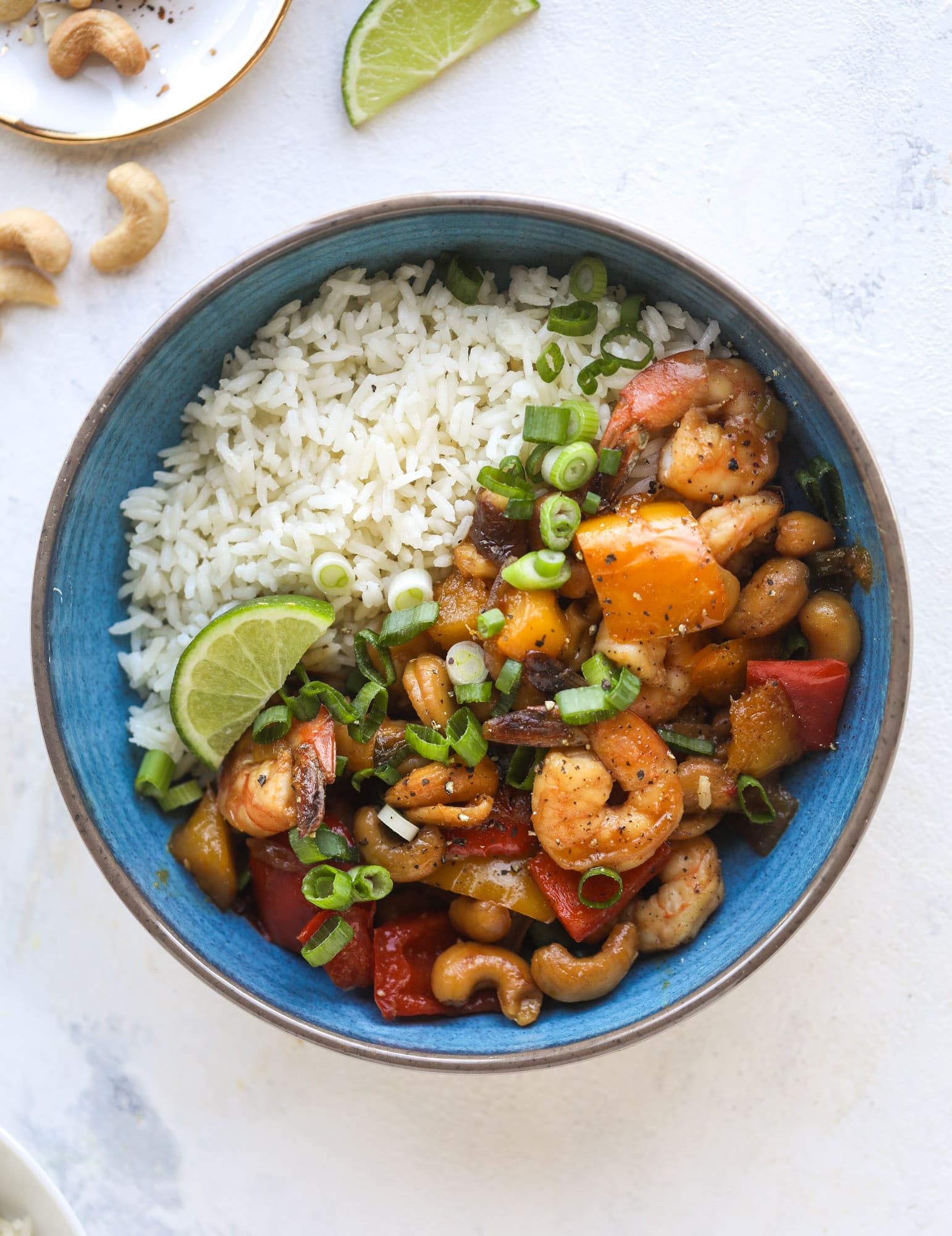 This cashew shrimp stir fry is a super simple weeknight meal! Made with bell peppers and mango, it is delicious over rice and comes together in 25 minutes. I howsweeteats.com #cashew #shrimp