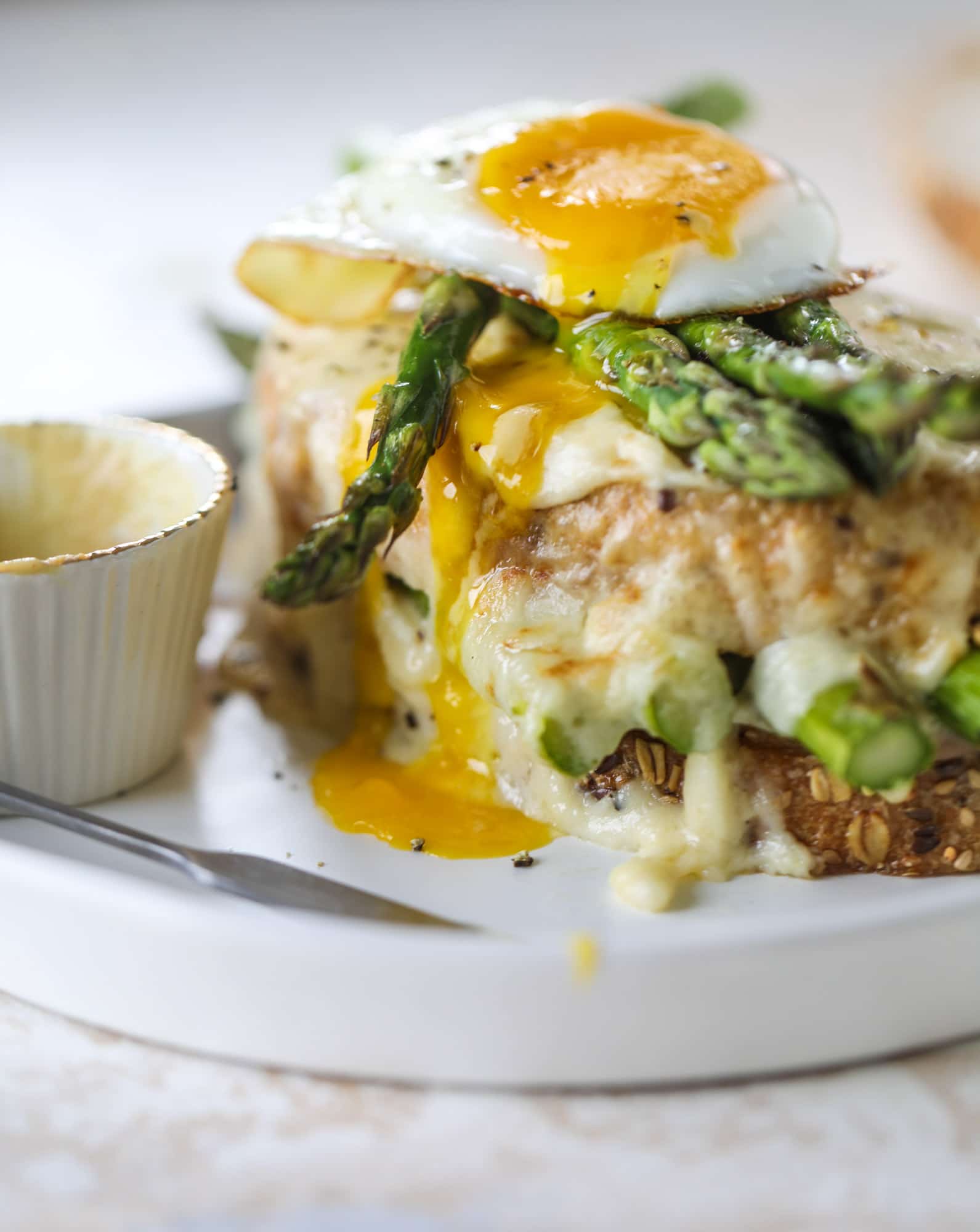 This roasted asparagus croque madame is made with thinly-sliced prosciutto and a fontina cheese sauce. Lots of dijon and an egg on top! I howsweeteats.com #croquemadame #asparagus
