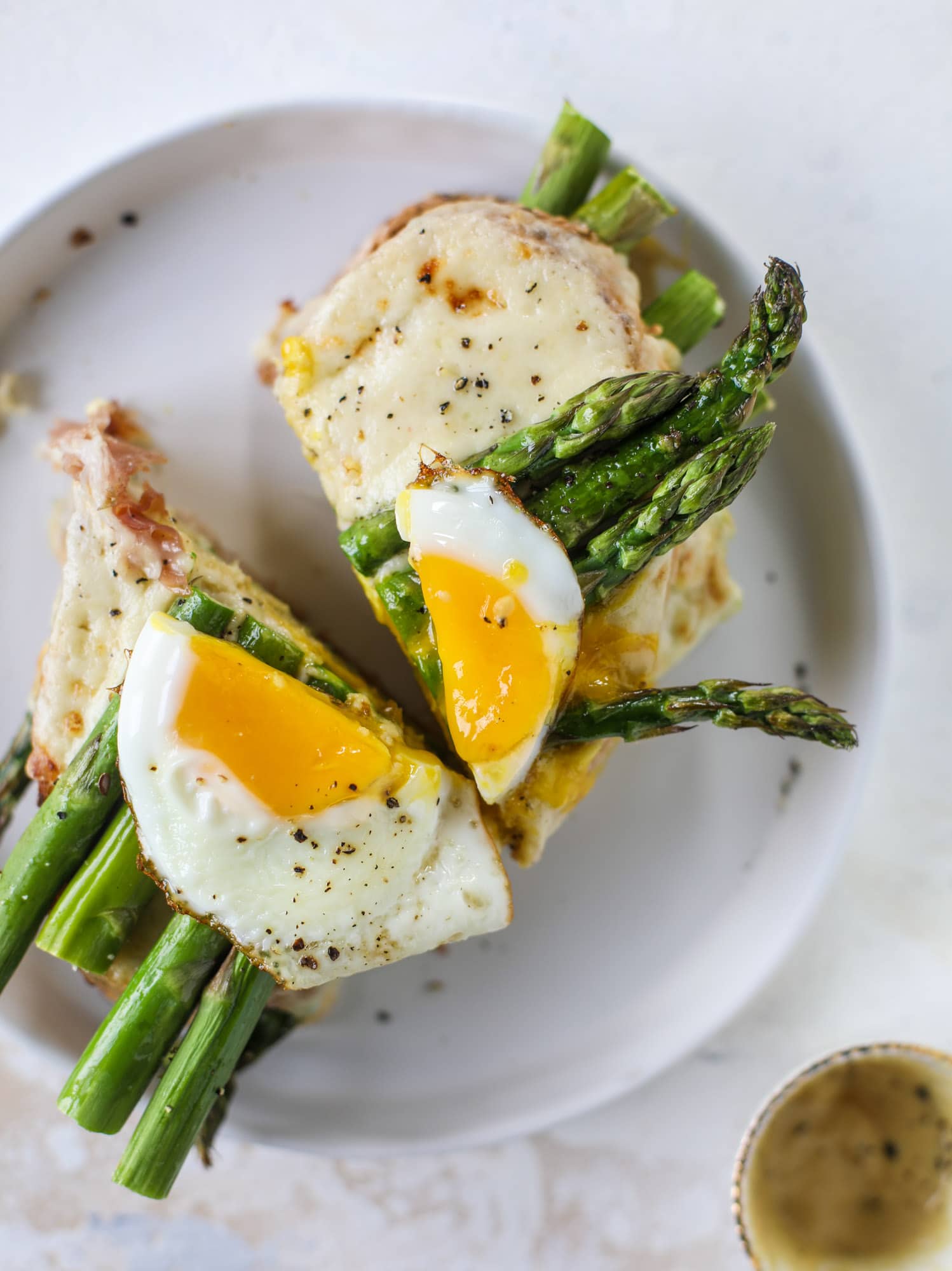This roasted asparagus croque madame is made with thinly-sliced prosciutto and a fontina cheese sauce. Lots of dijon and an egg on top! I howsweeteats.com #croquemadame #asparagus