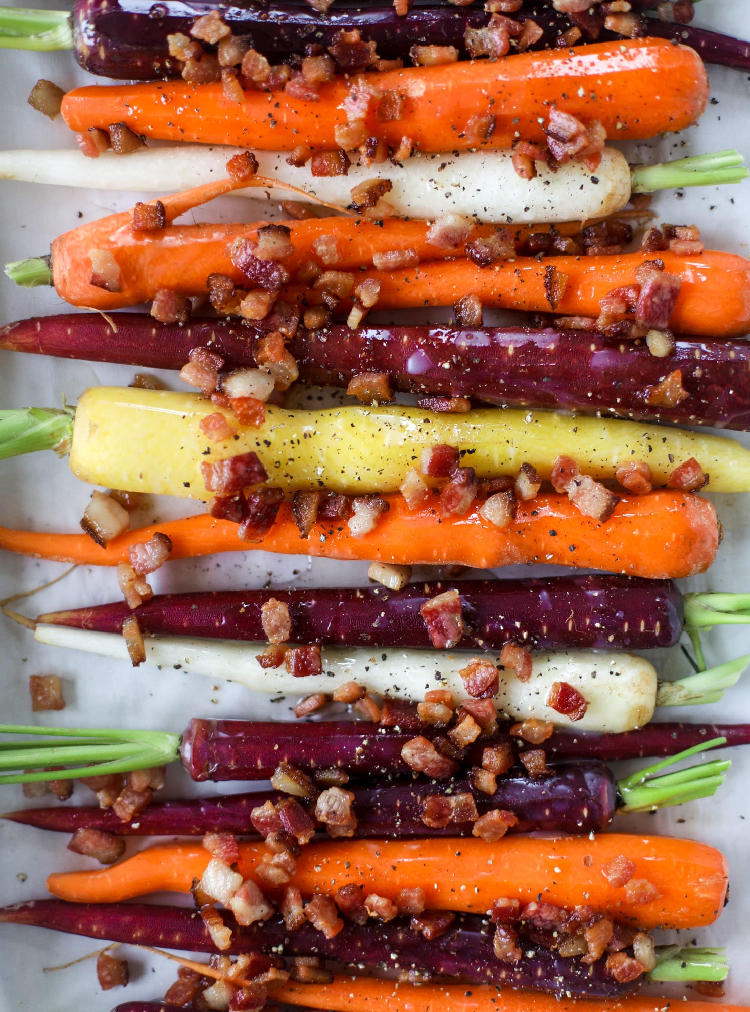 Sweet carrots are drizzled with bacon fat and chopped bacon, then roasted until they are tender, sweet and caramely. So much flavor!