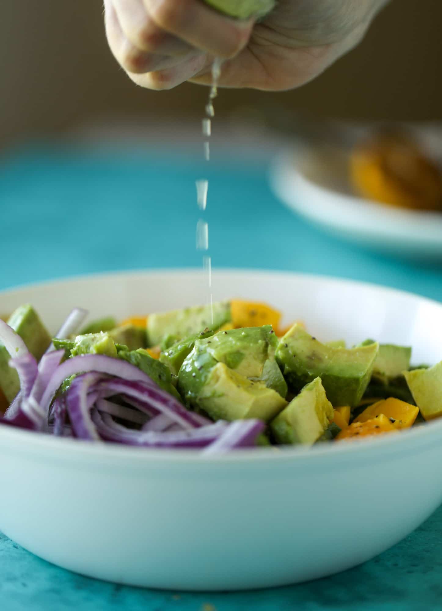 squeezing lime juice on avocado salad