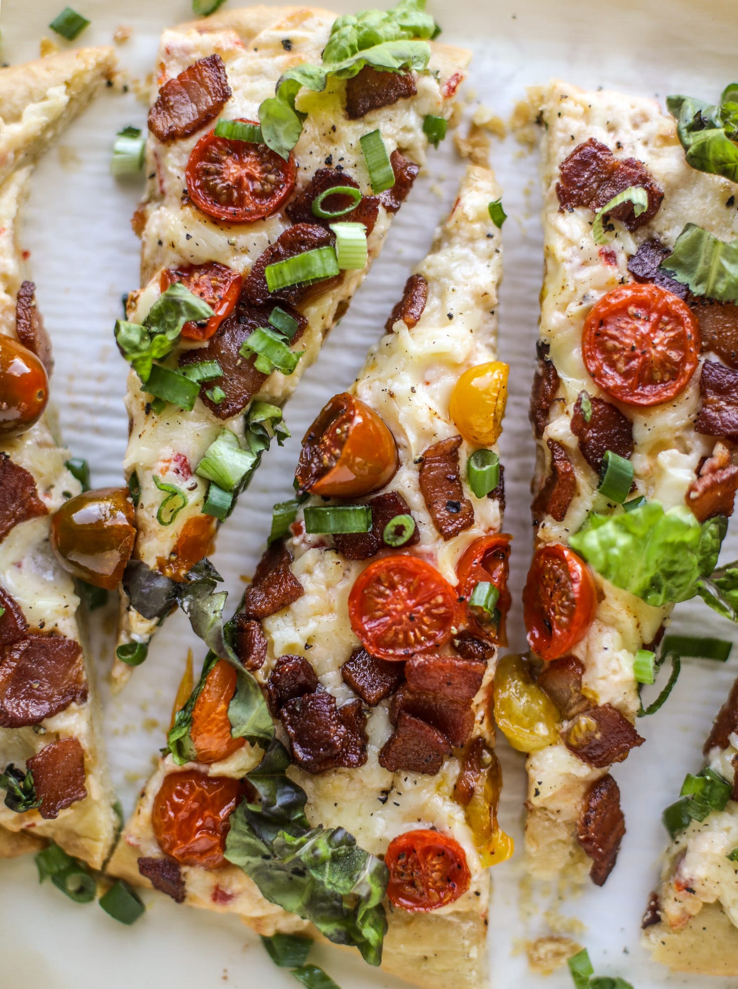 A crisped flatbread crust is topped with creamy pimento cheese, crispy bacon, garlic burst tomatoes and shredded lettuce. It's a flavor explosion!