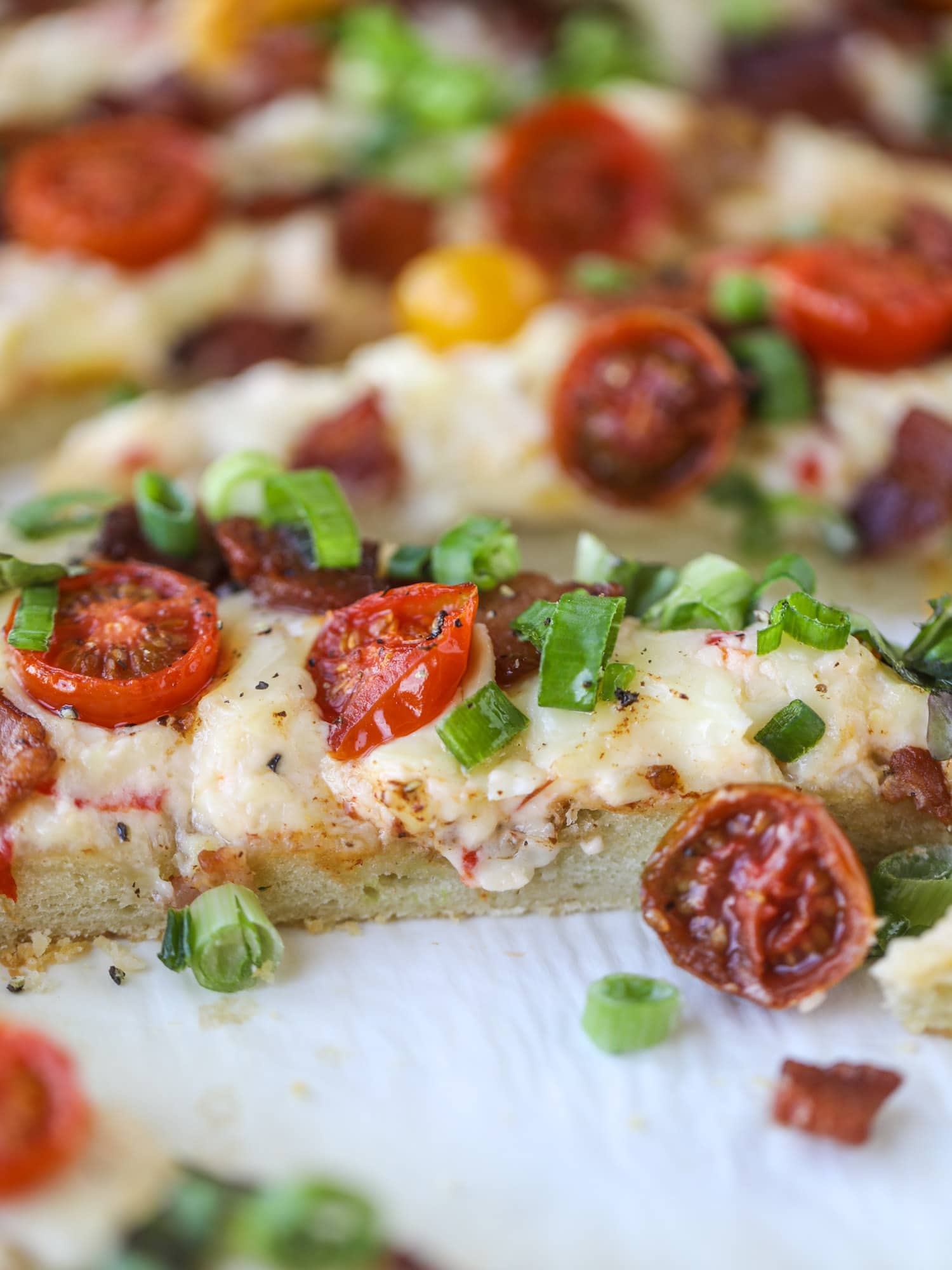 A crisped flatbread crust is topped with creamy pimento cheese, crispy bacon, garlic burst tomatoes and shredded lettuce. It's a flavor explosion!